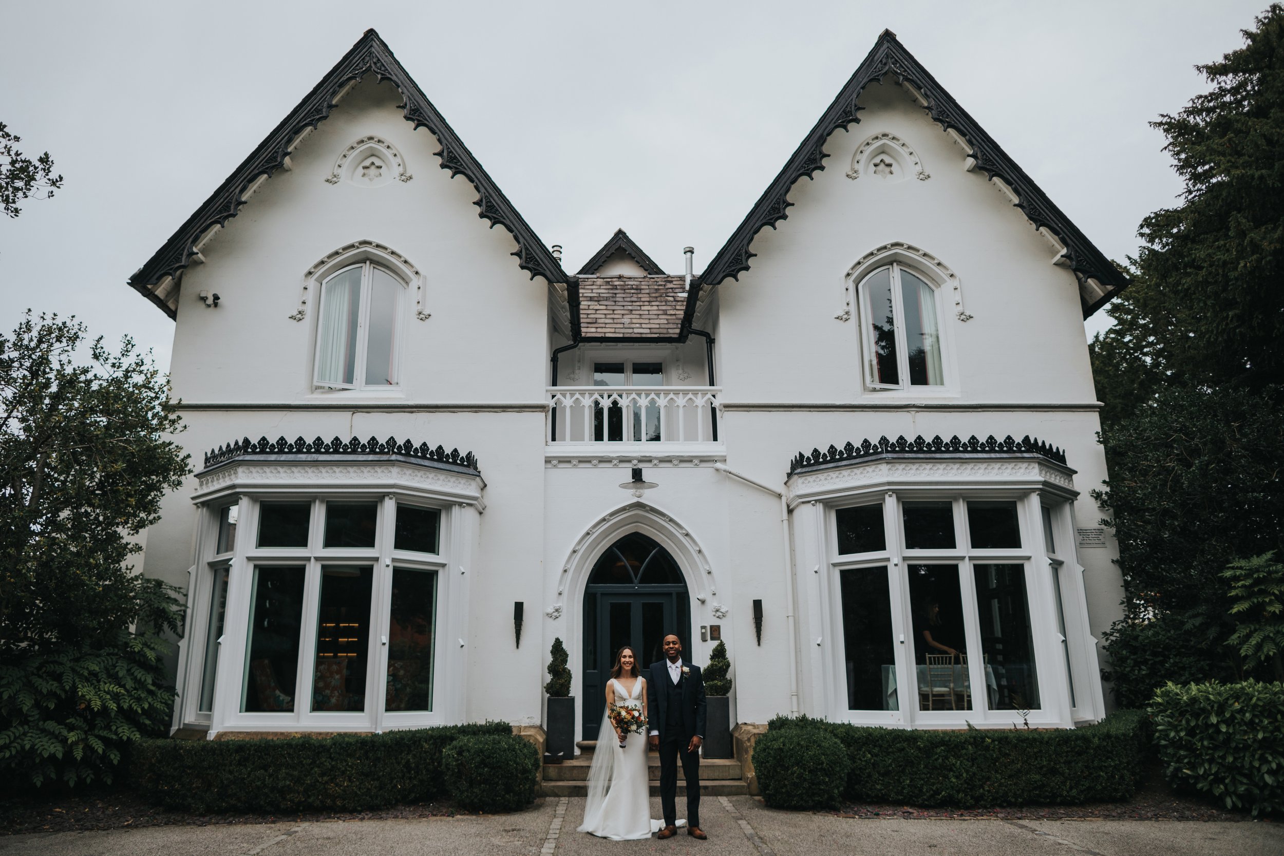 Bride and Groom stand together in front of Didsbury House Hotel. 