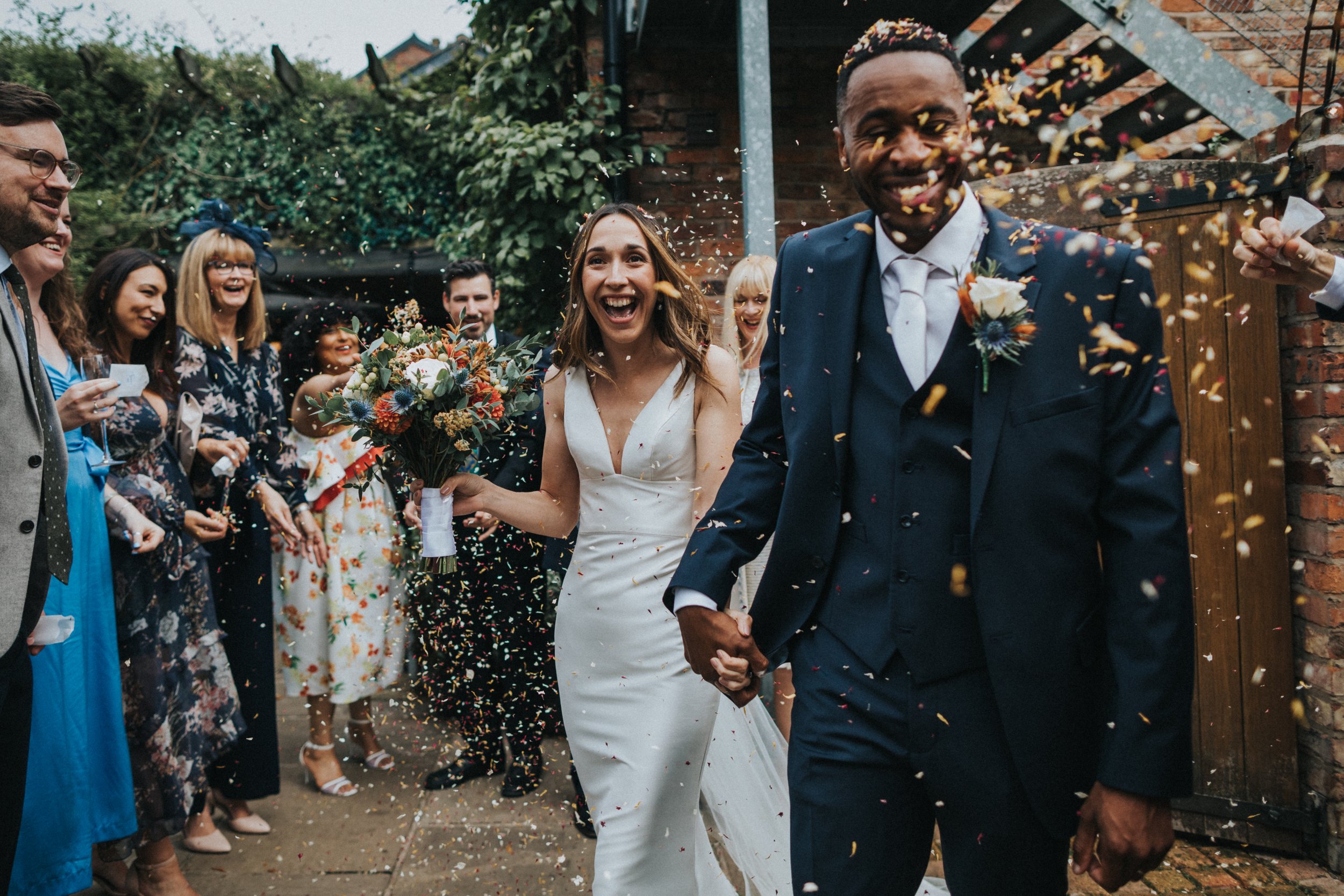 Bride and Groom are ambushed with confetti.