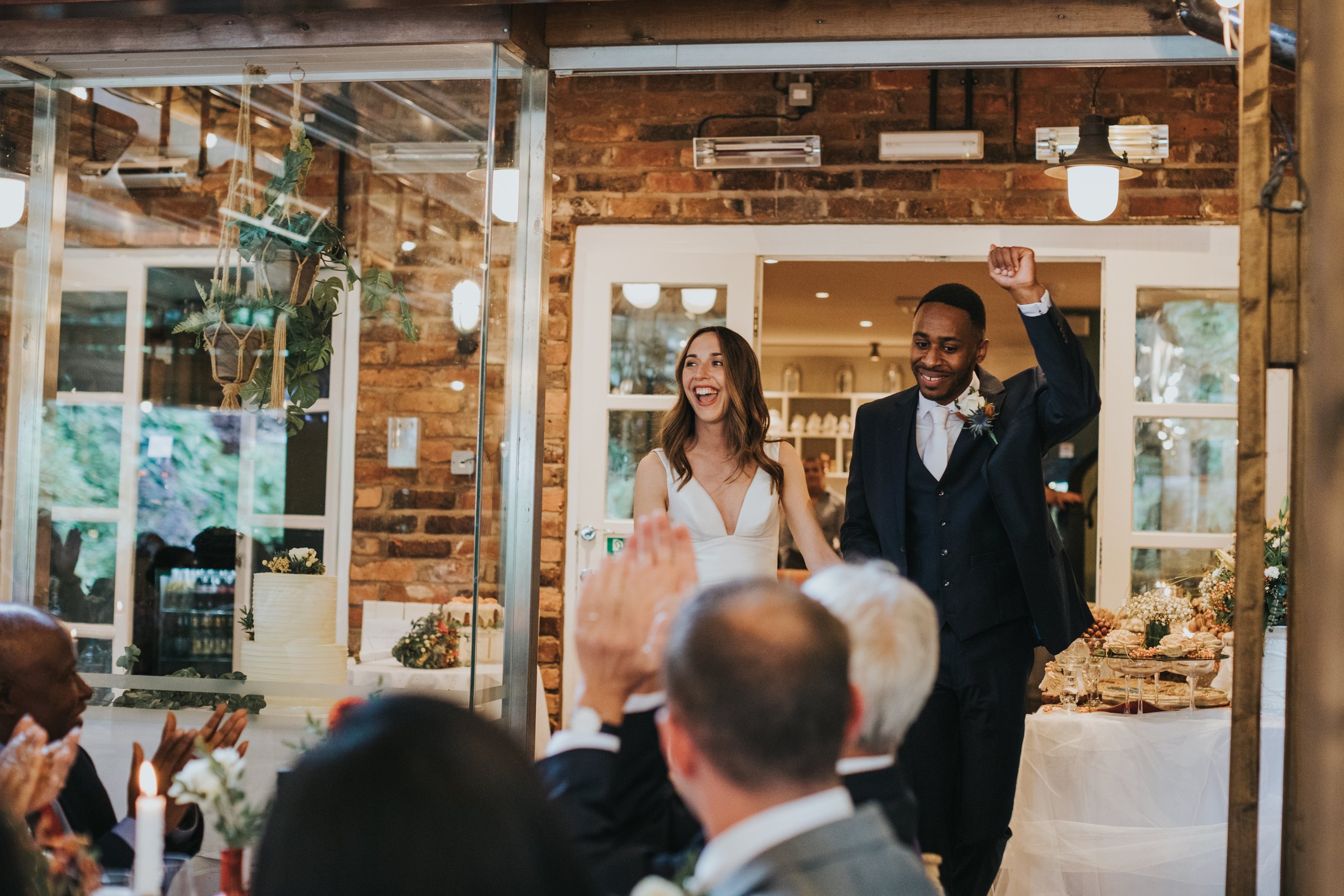 Bride and groom enter their wedding breakfast to a round of applause. 