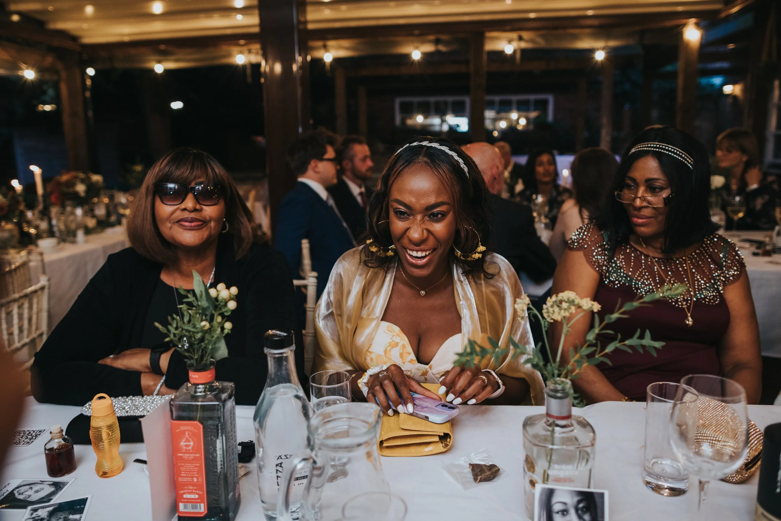 Wedding guests sitting at table laughing. 