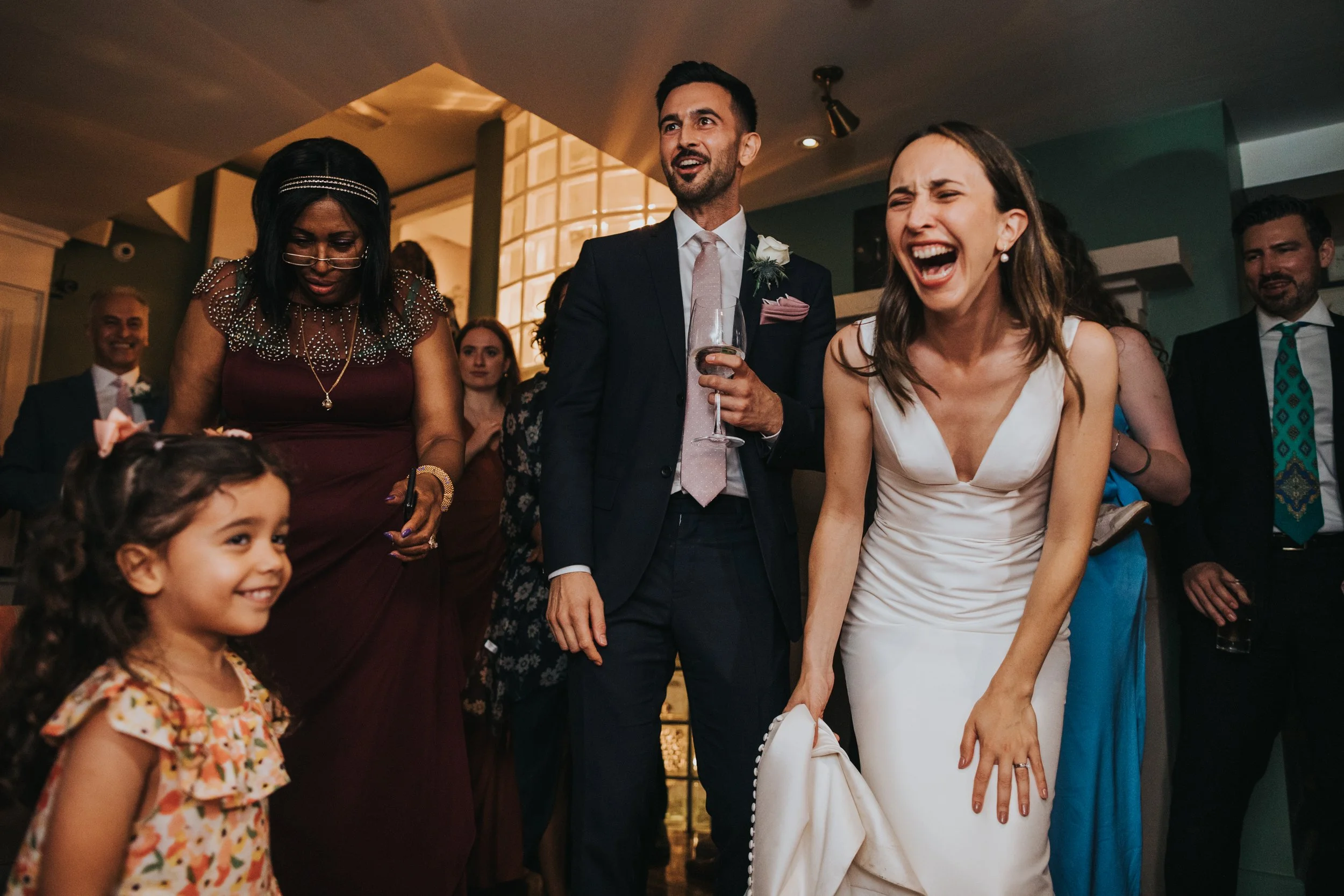 Bride laughing at children dancing. 