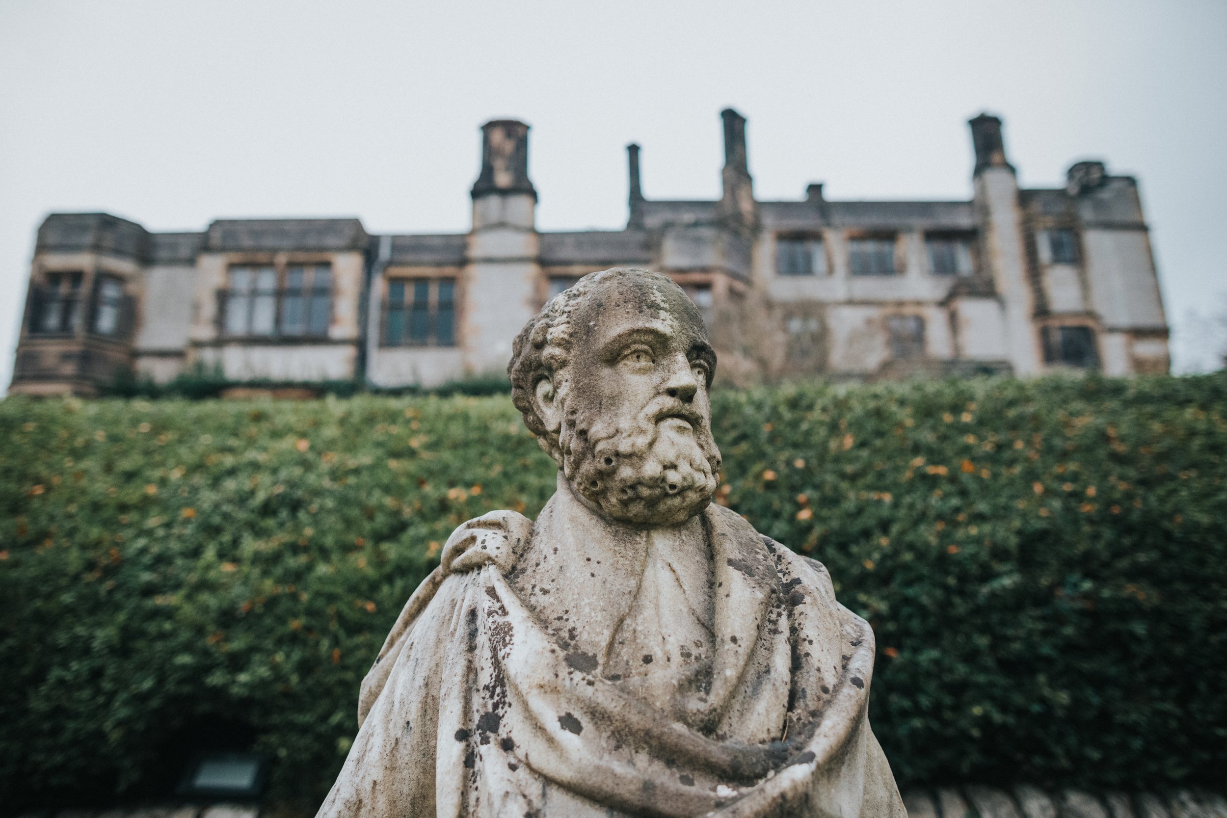 Statue of a bearded man in Thornbridge Hall Formal Gardens