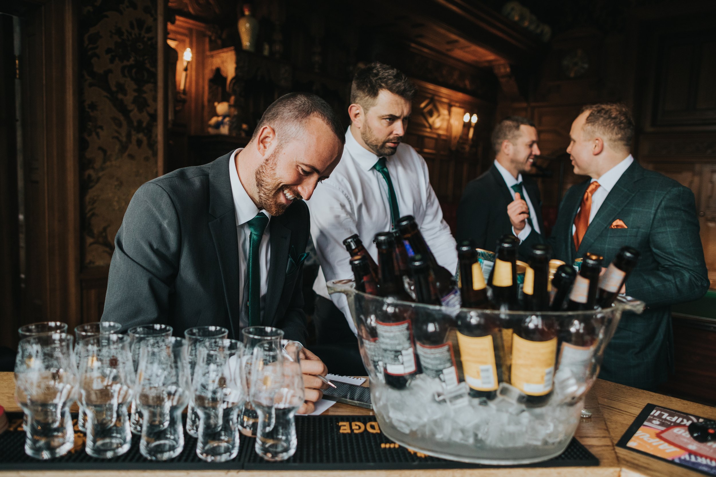 Groomsmen enjoy some beers in the pool room. 