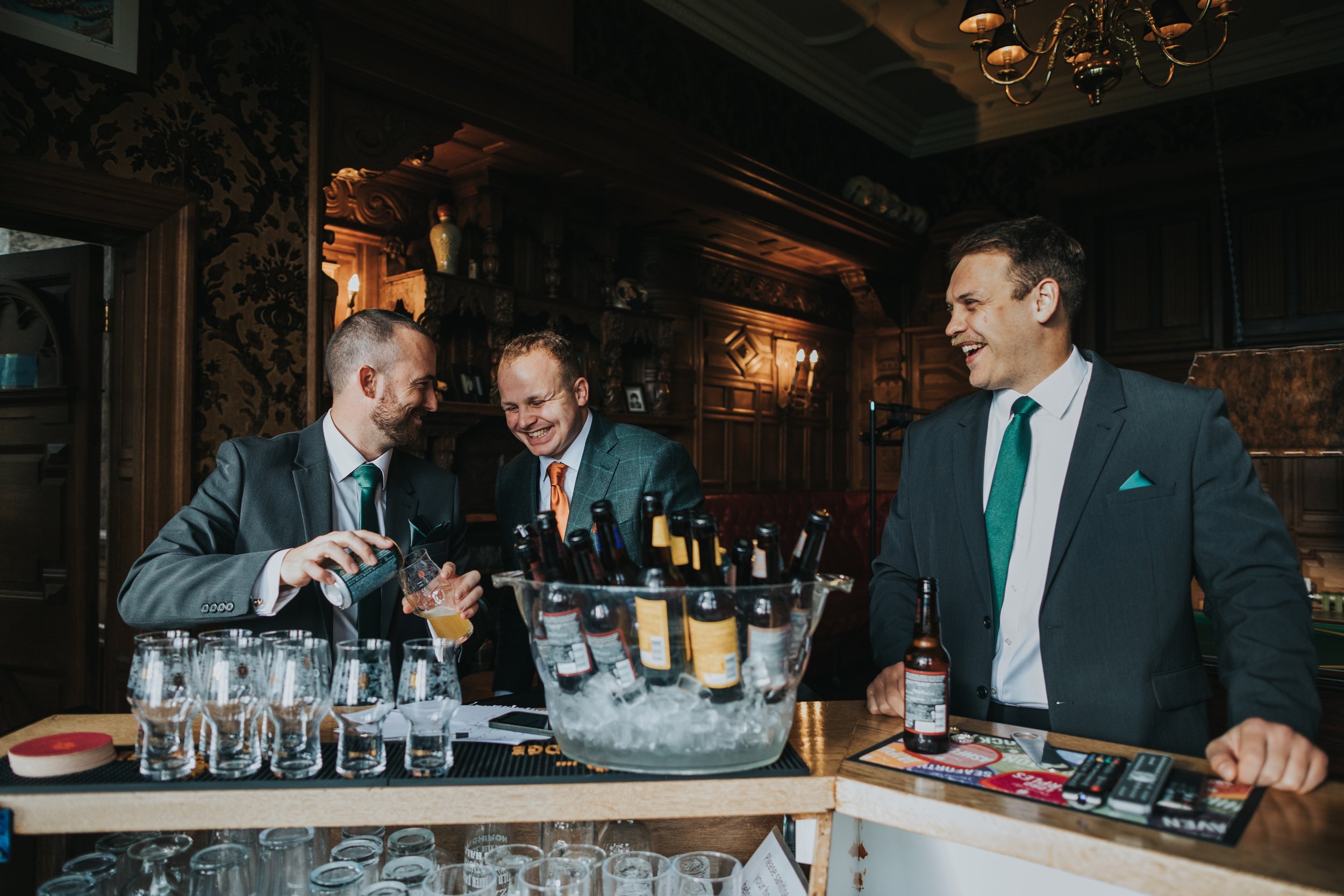 Groomsmen laugh together while writing their speeches. 
