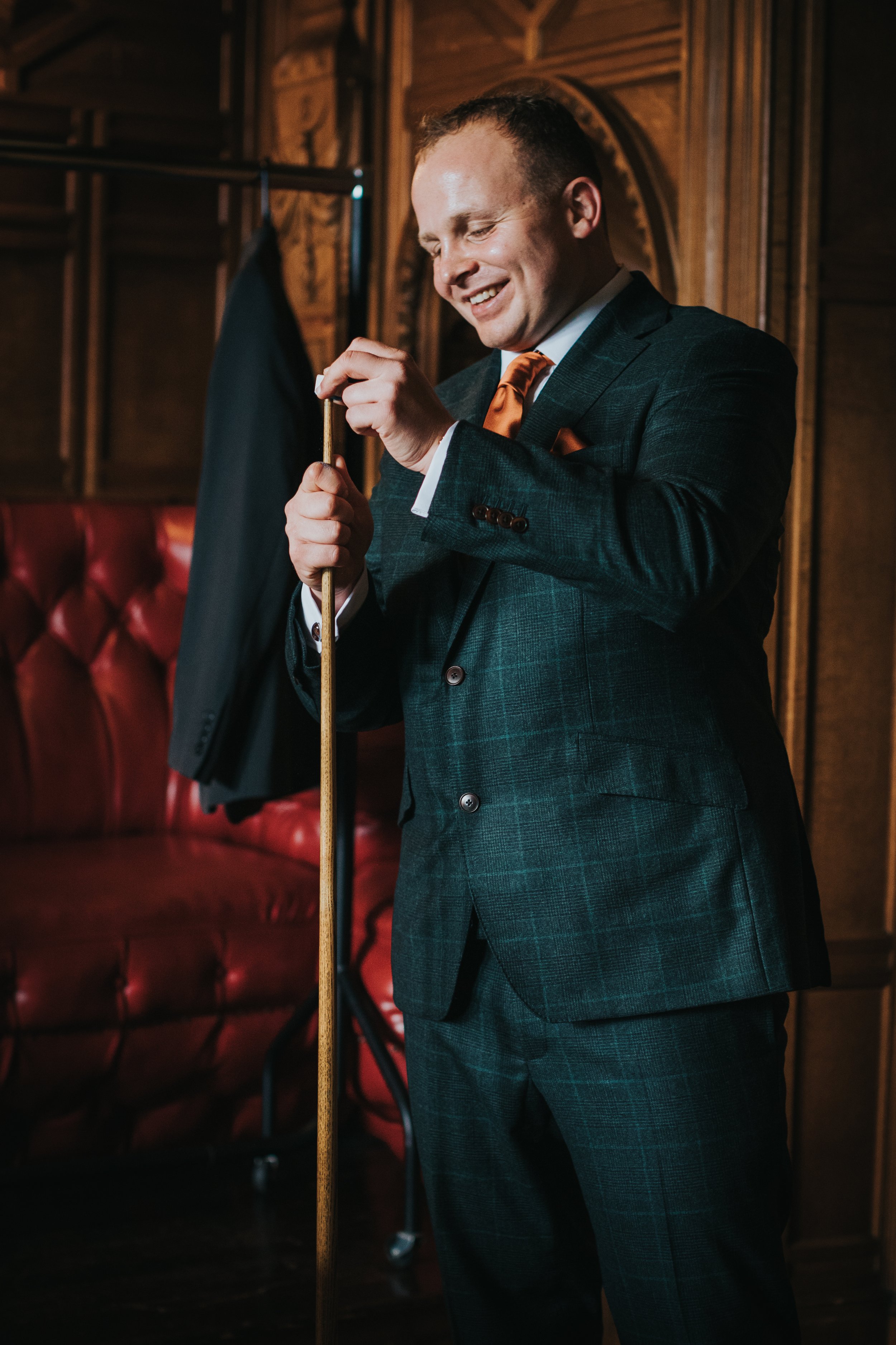 Groom chalks his pool cue. 