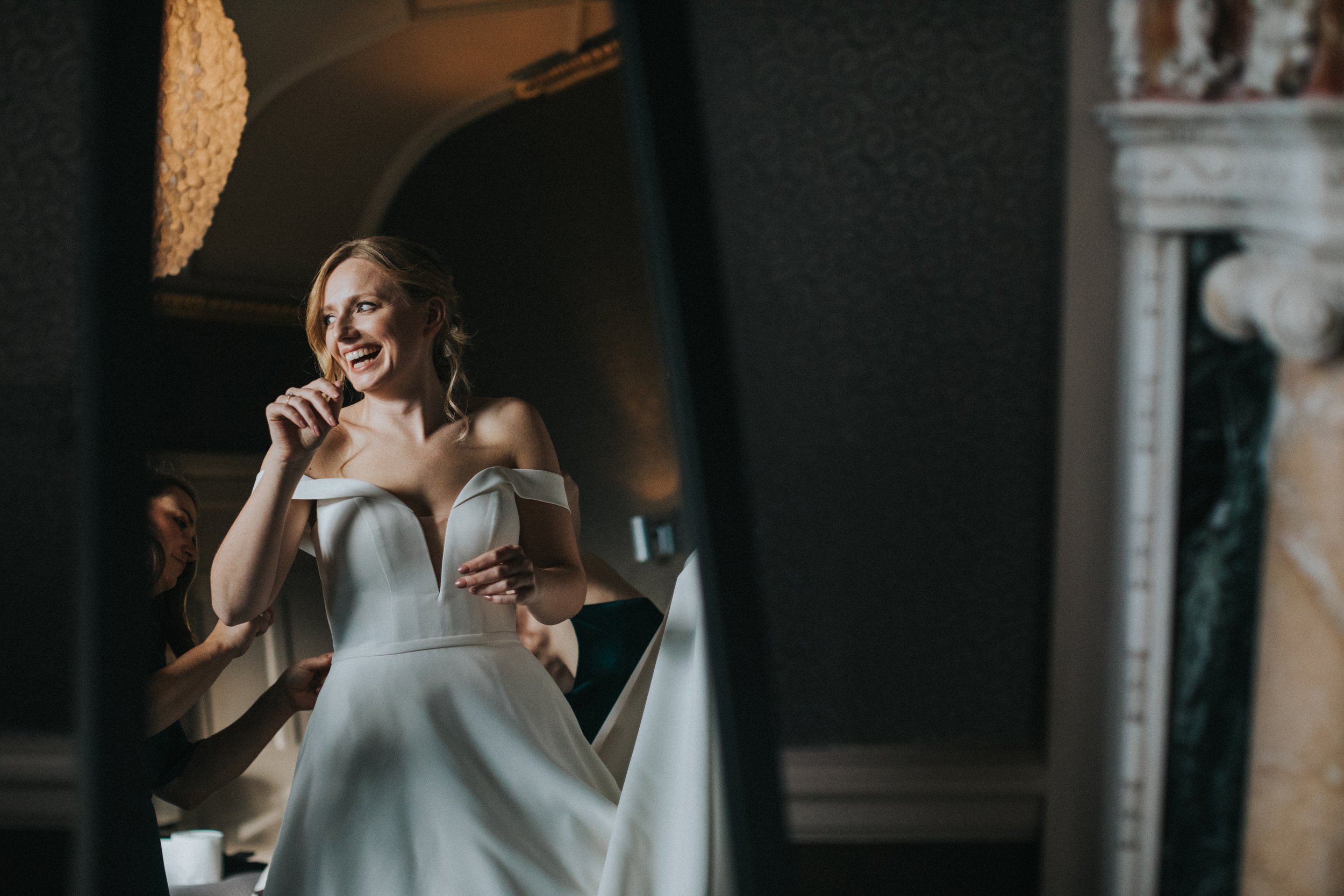 Bride reflected in mirror laughing. 