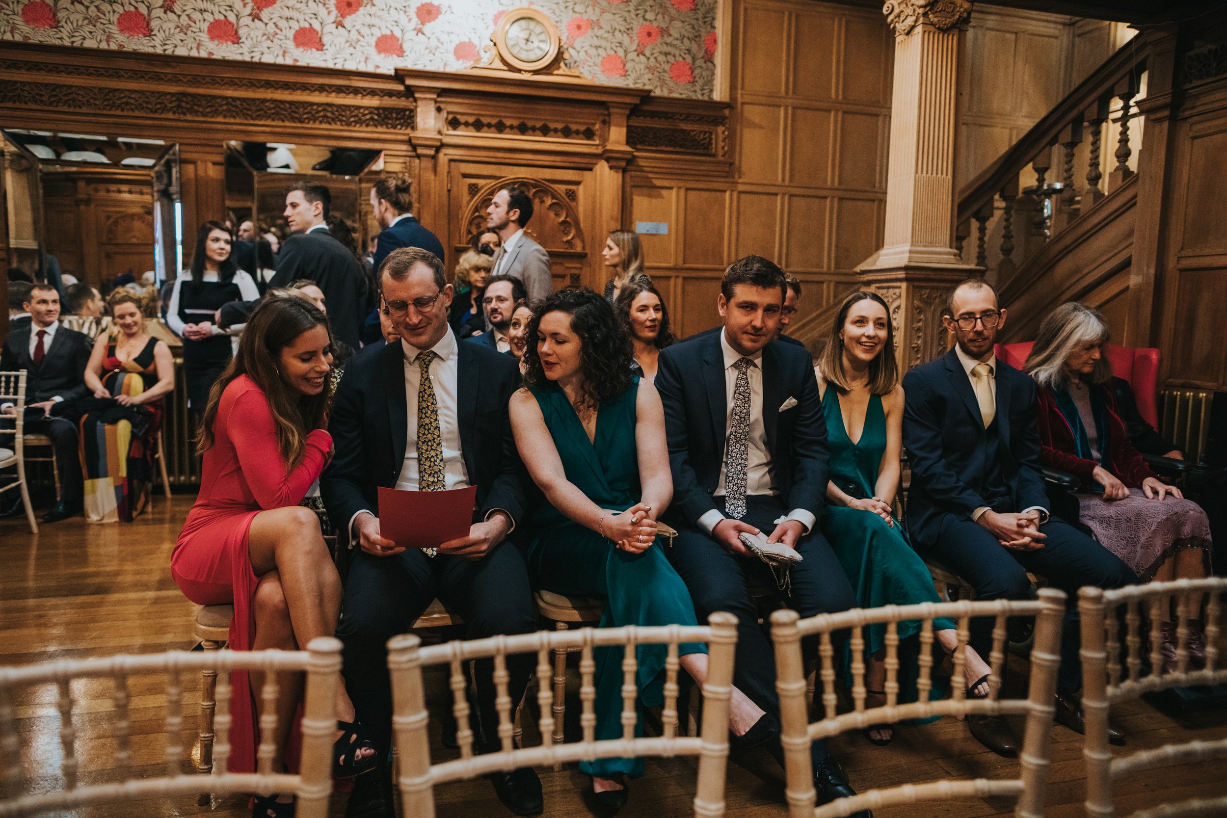 Guests huddle together to facetime a friend on an ipad. 