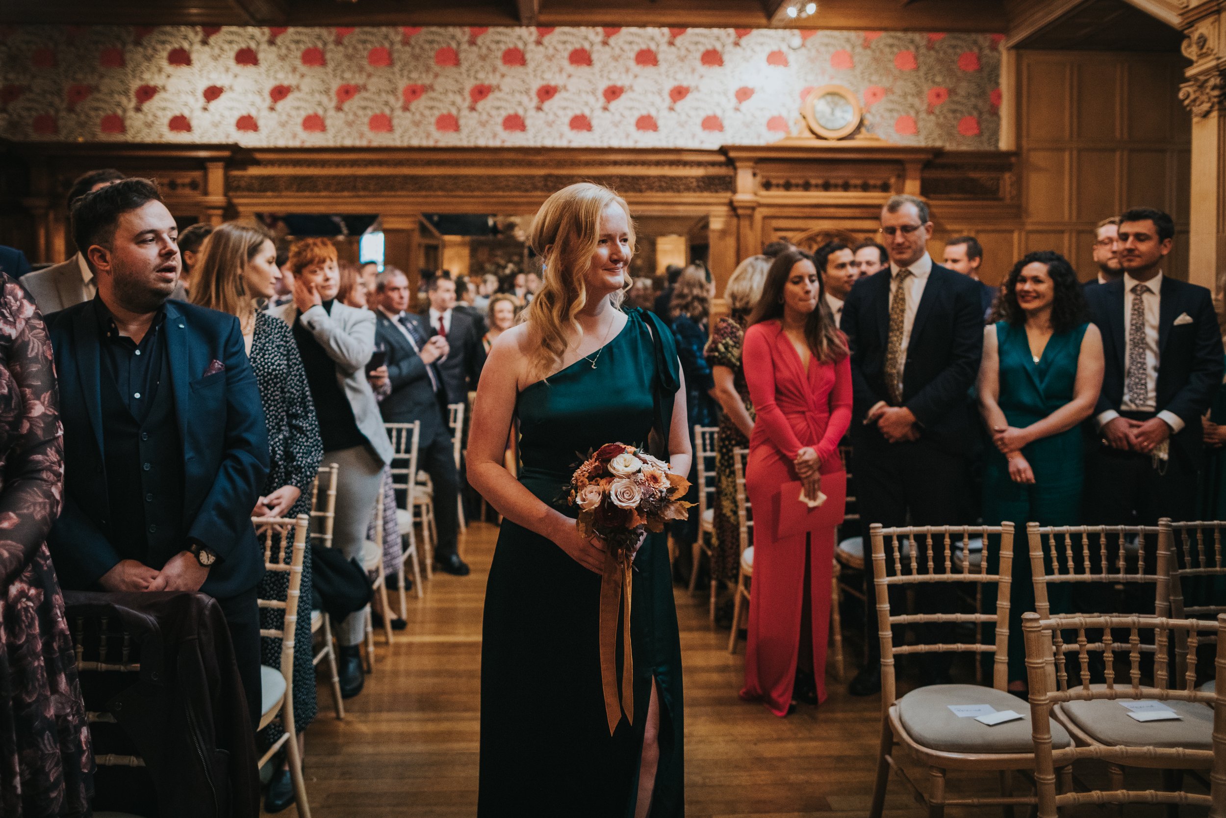 Sister of the bride walks down the aisle alone. 