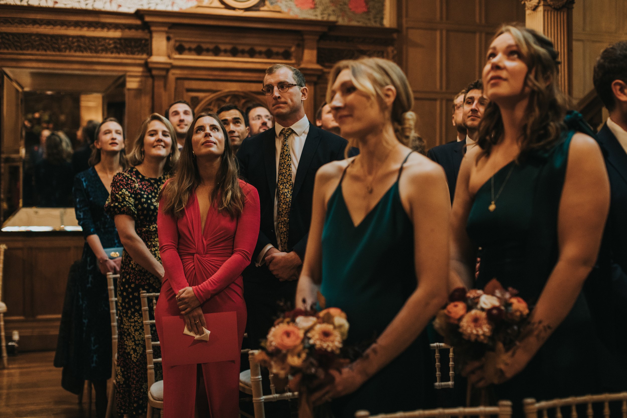 Bridesmaids and guests look up as the bride circles them from above