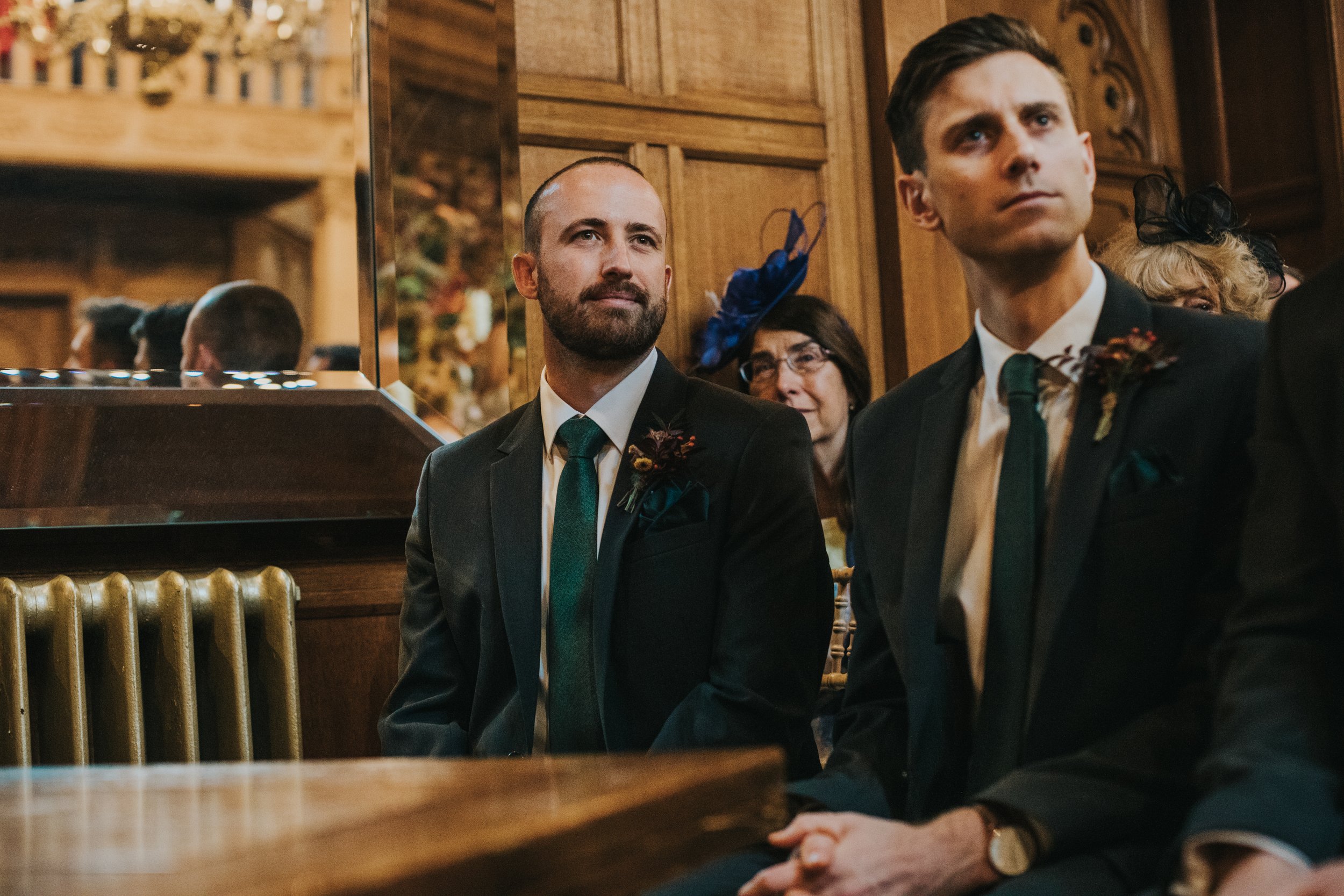 Groomsman watches the couple smiling