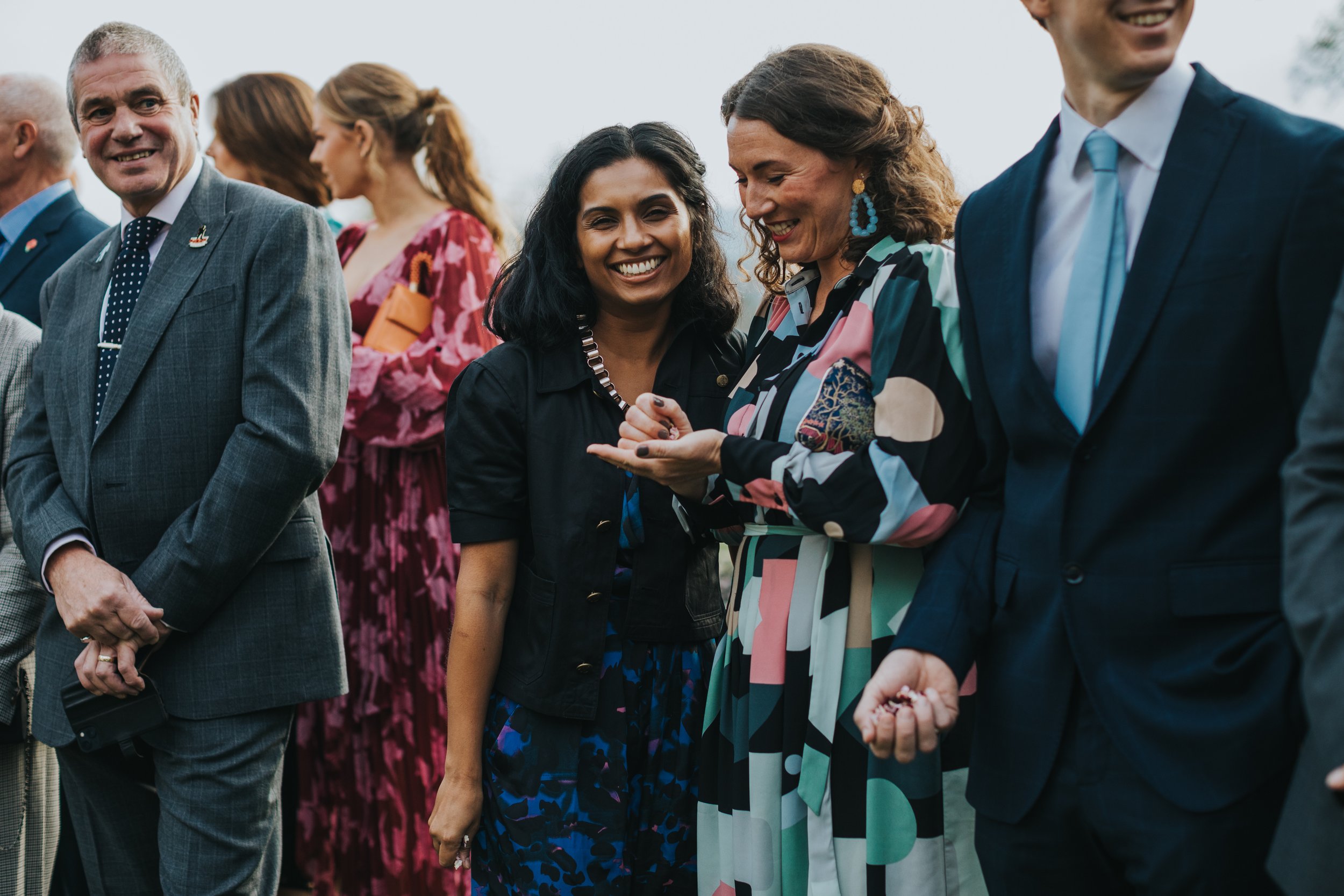 Wedding guests smile while they wait. 