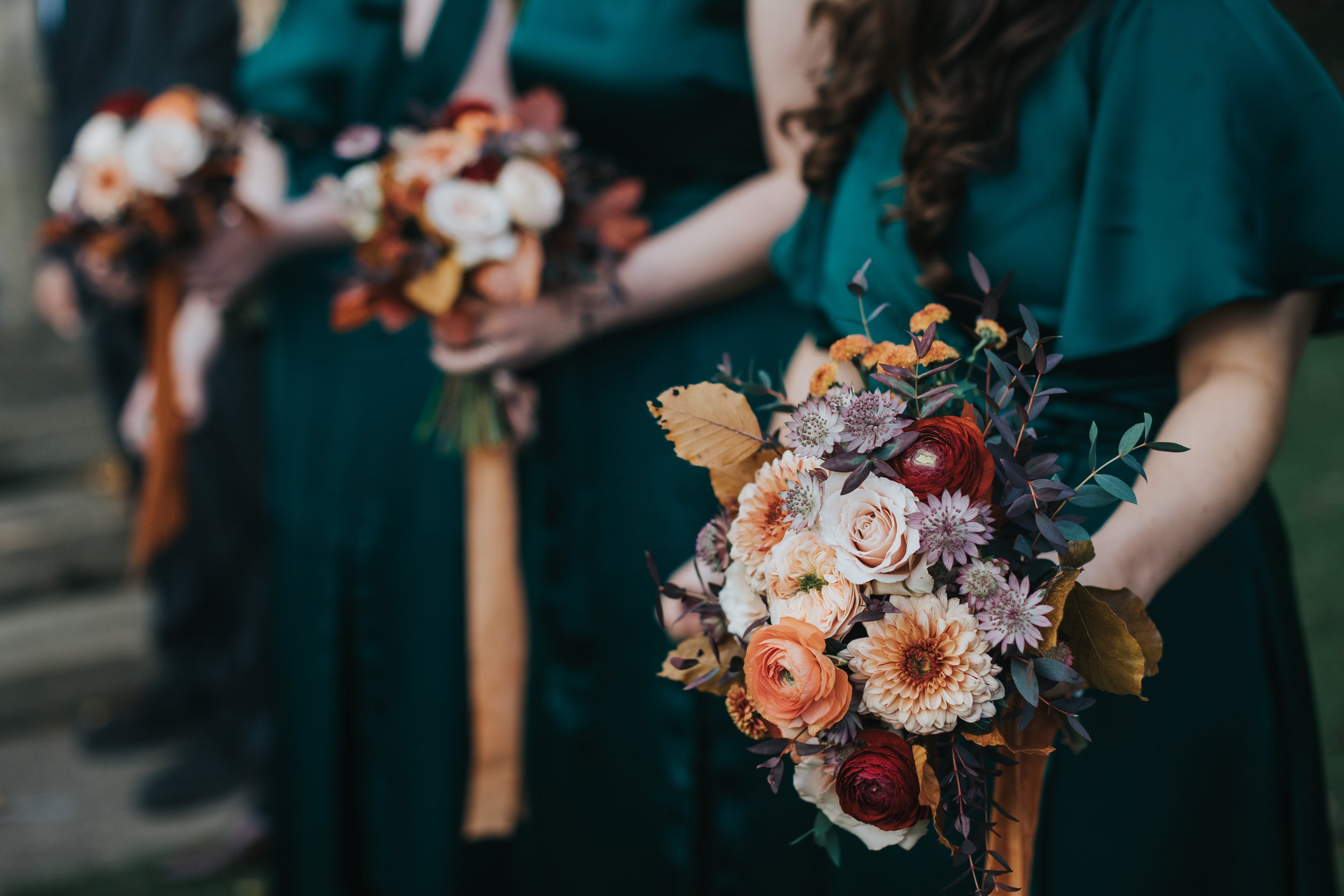 Close up of the bridesmaids holding their autumnal flowers. 