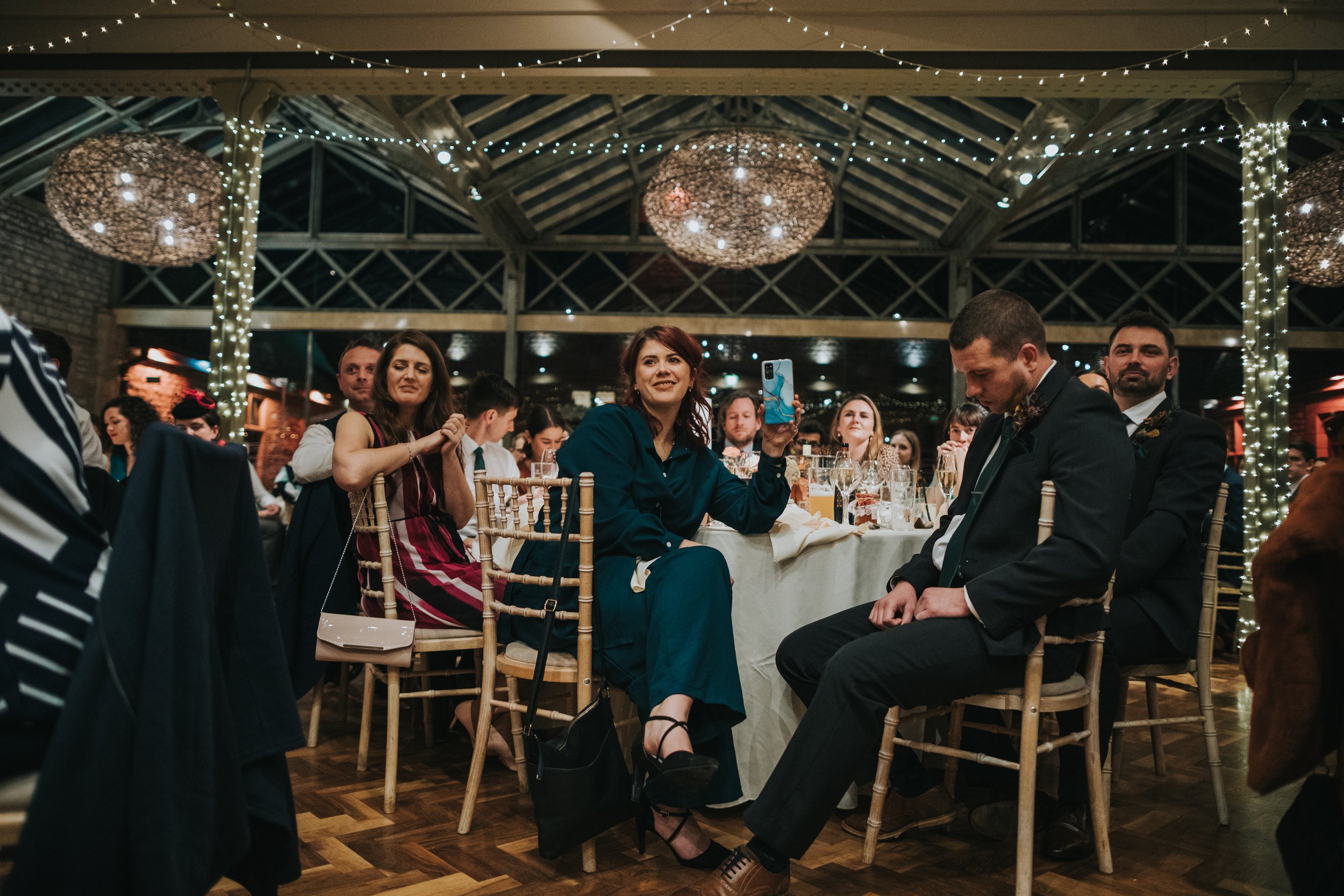 Wedding guest filming speeches on her phone. 