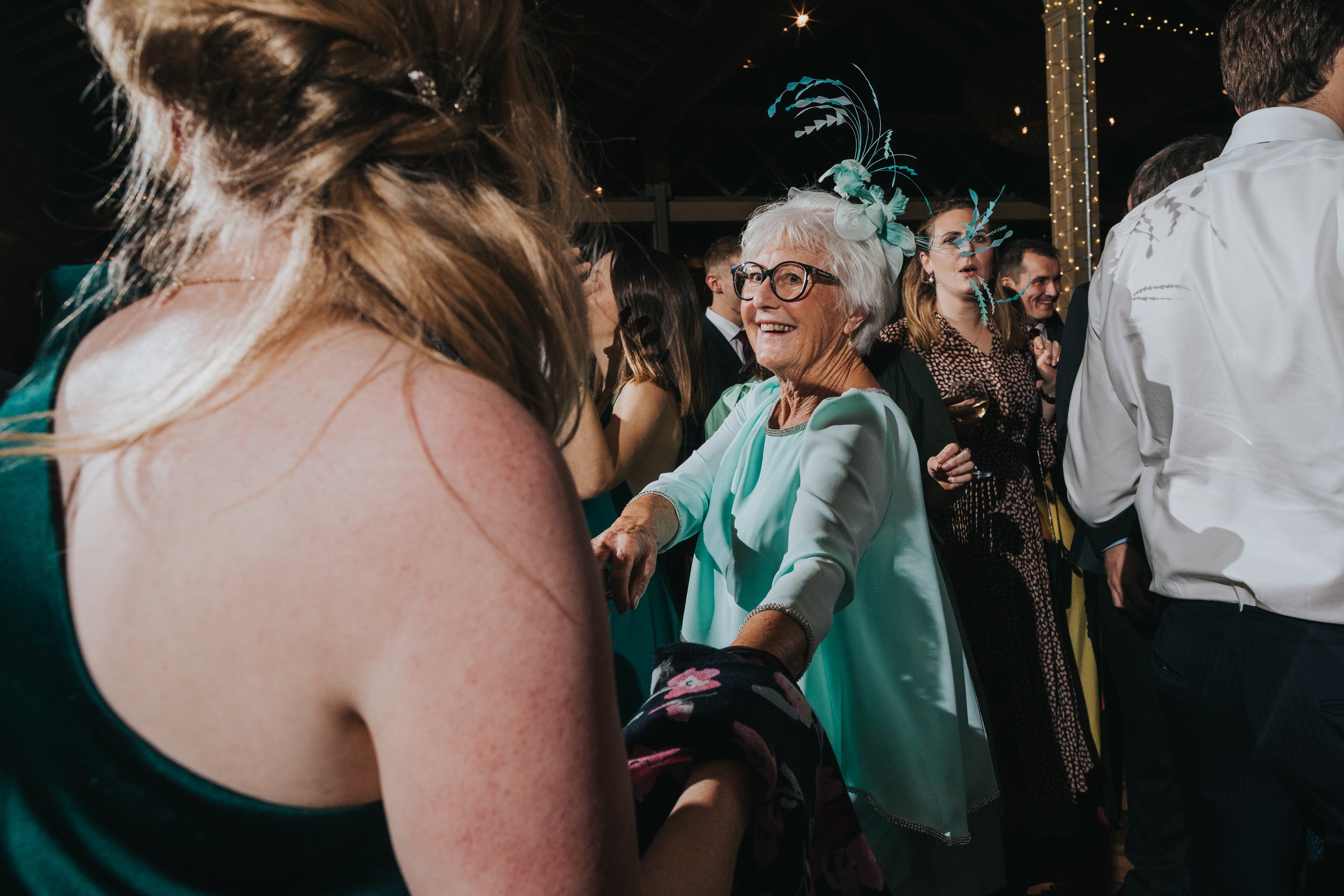 Mother of the bride dances with bridesmaid. 