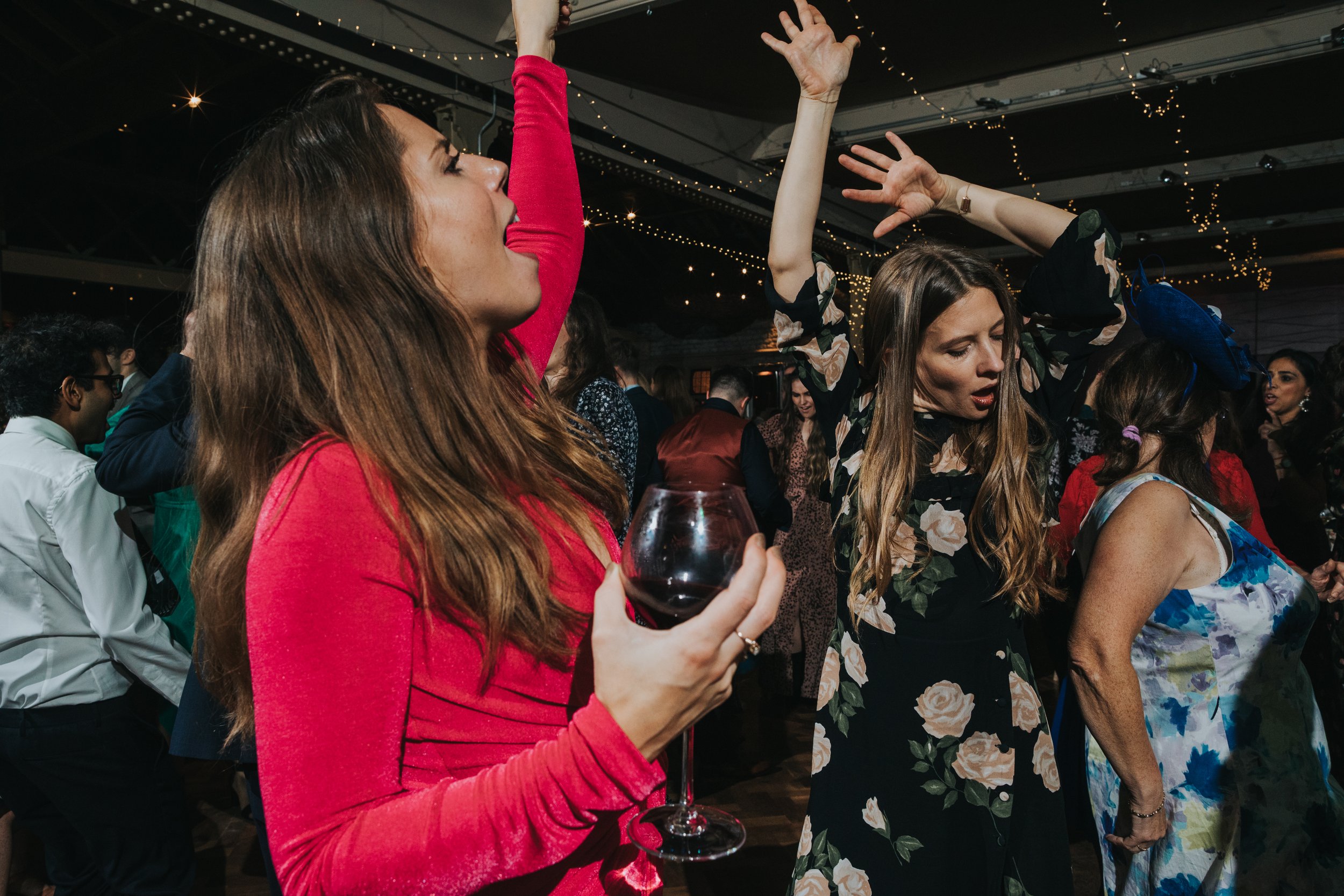 Female wedding guests throw some shapes. 