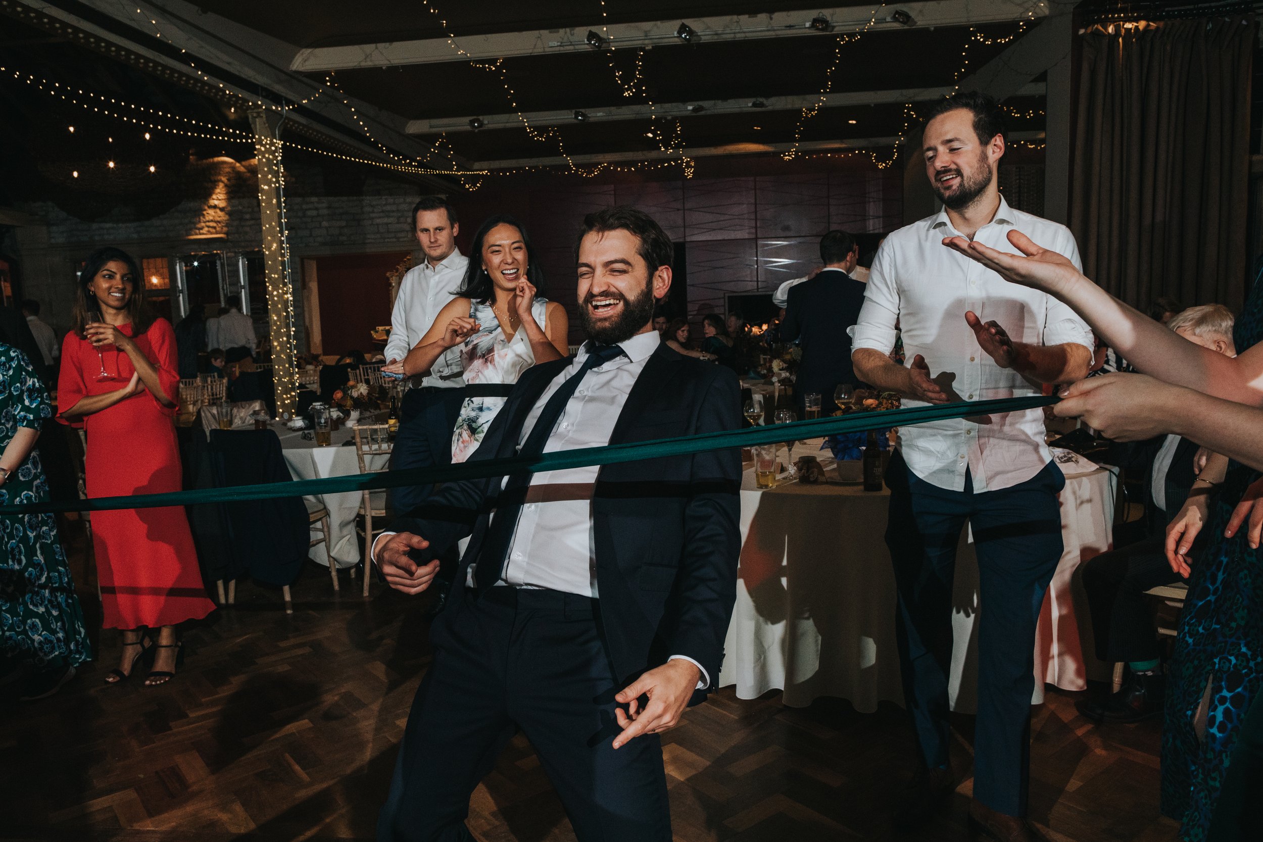 Adult laughs as he does the dance floor limbo. 