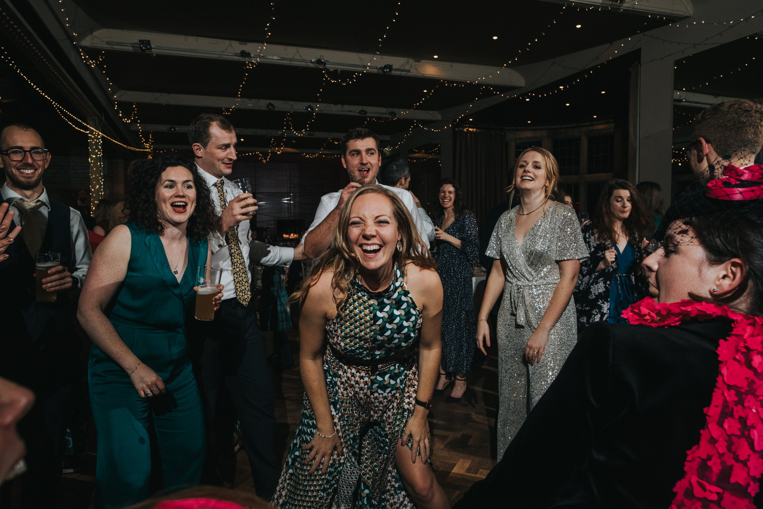 Wedding guests laughing and dancing at Thornbridge Hall. 