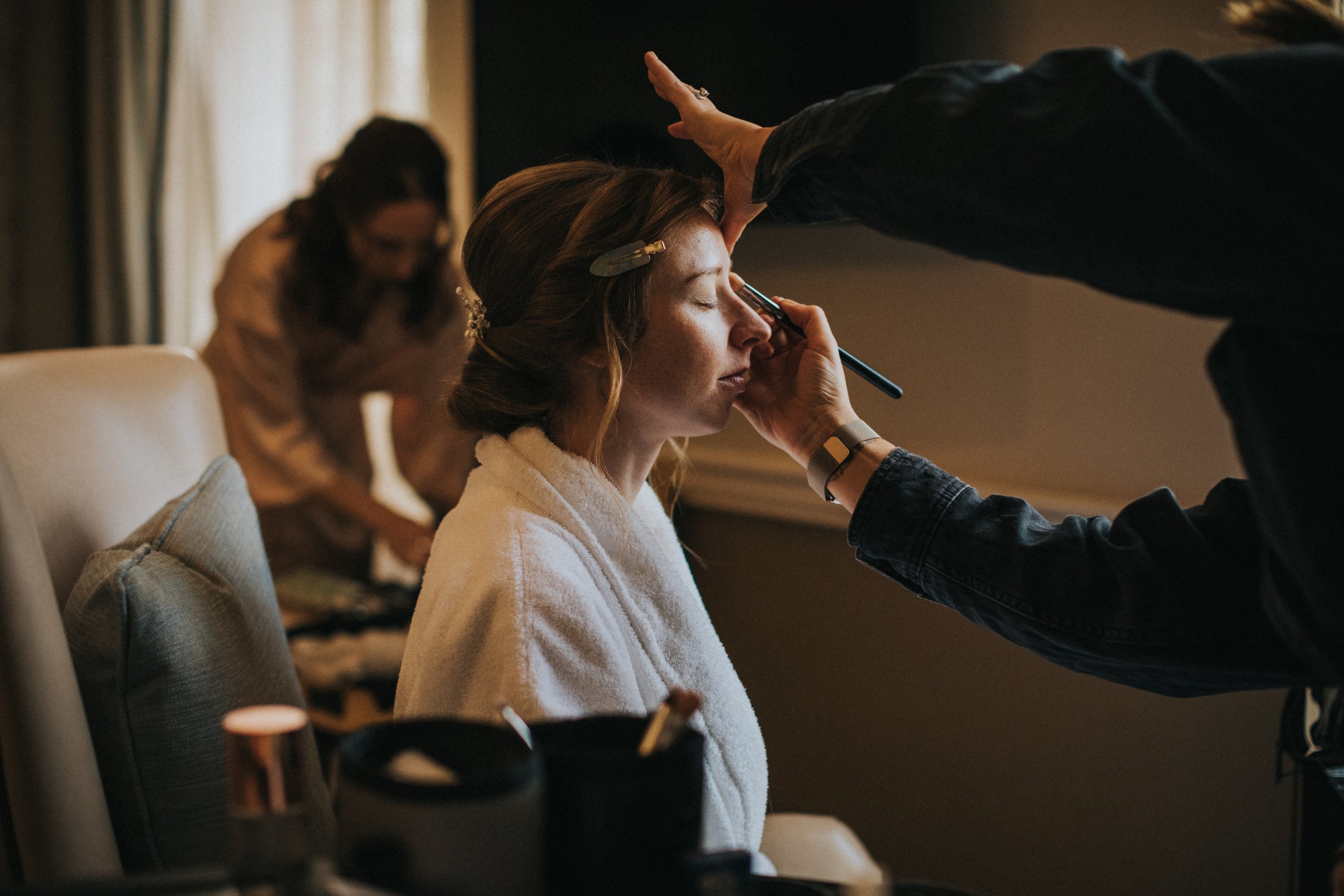 Bride getting the finishing touches of her  make up done. 