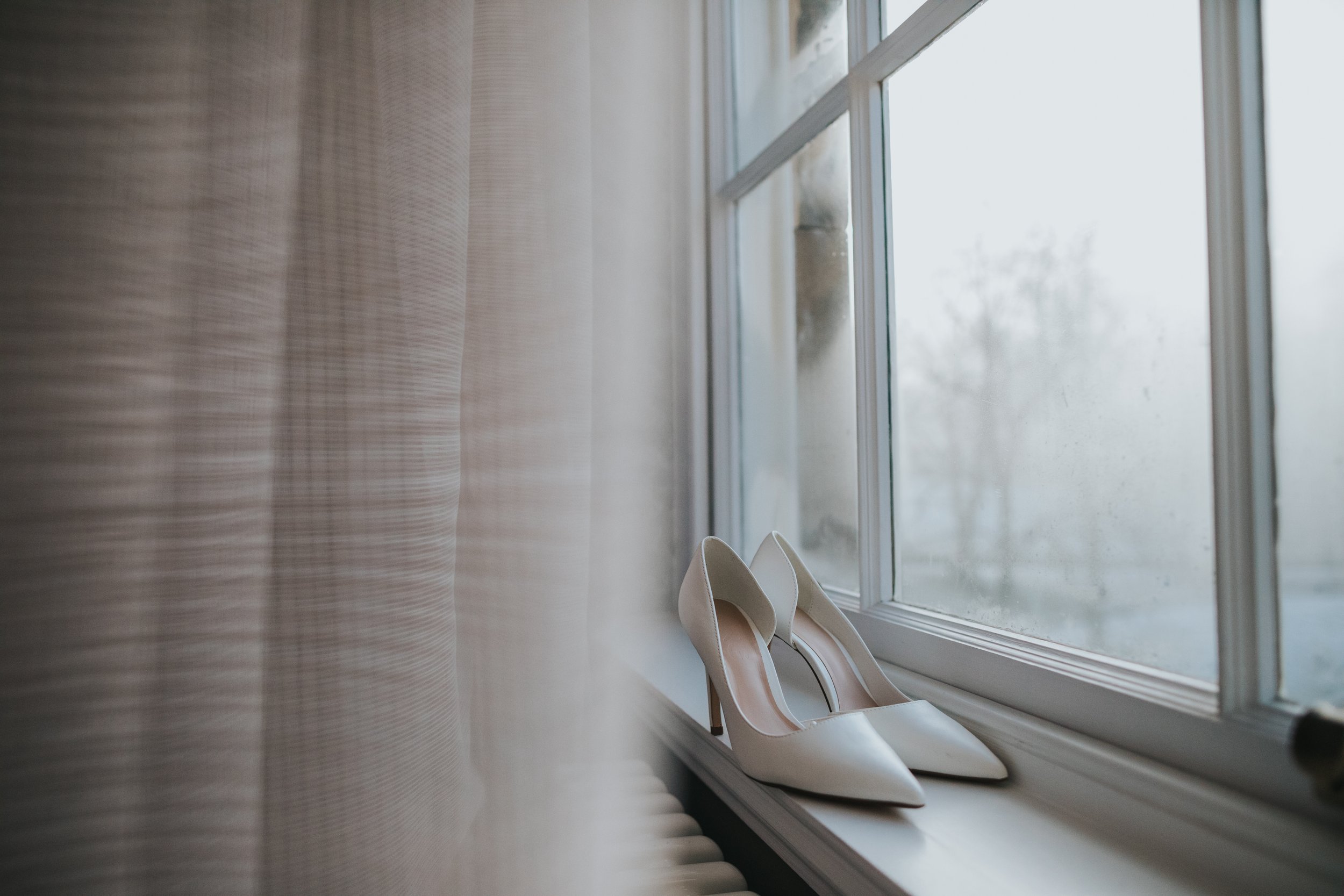 White bridal shoes on a windowsill.