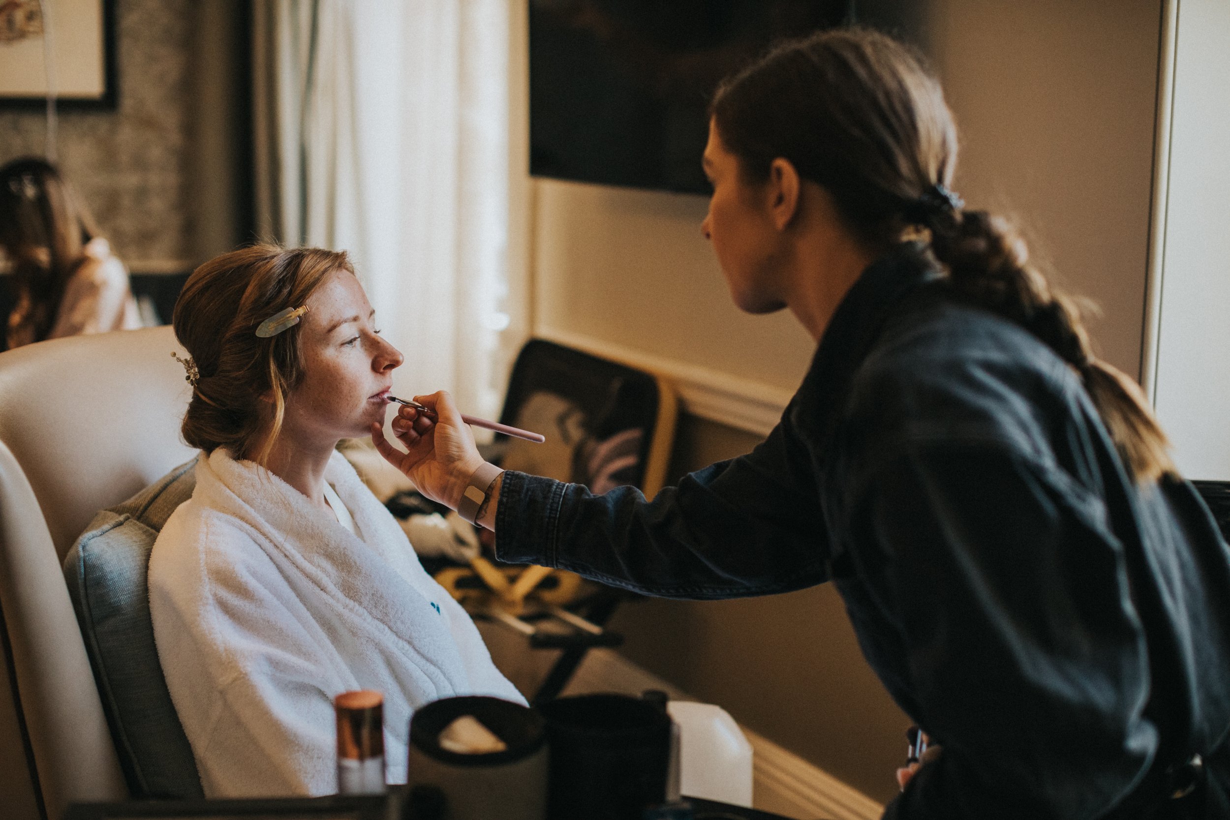 Bride has her lip stick put on by MUA 