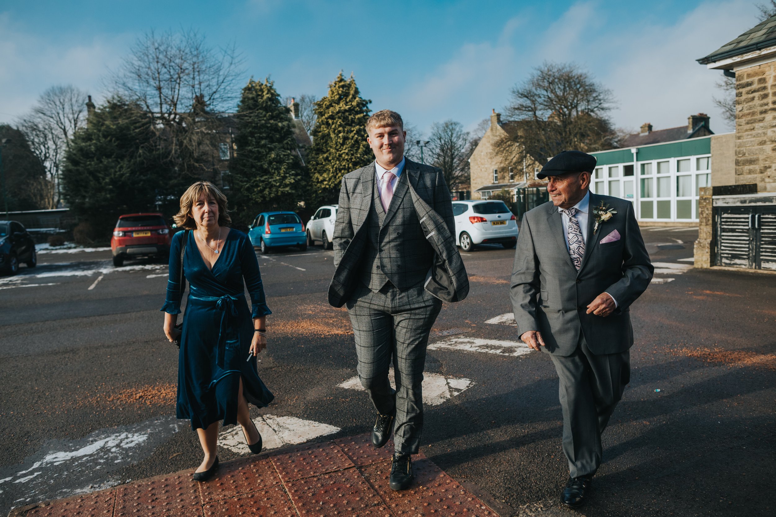 Grooms family walk together to the wedding venue on a cold winter morning.