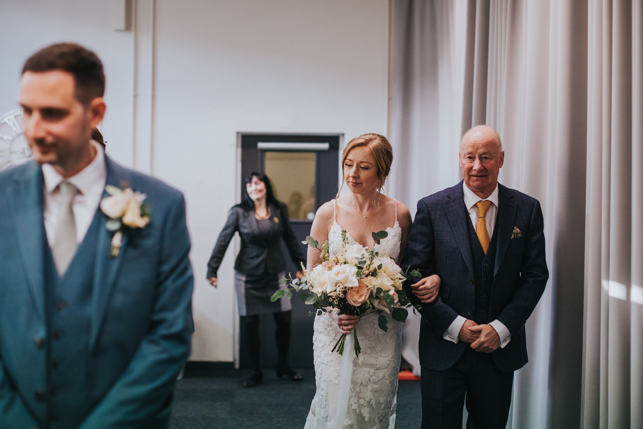 Bride walks down the aisle with her father. 