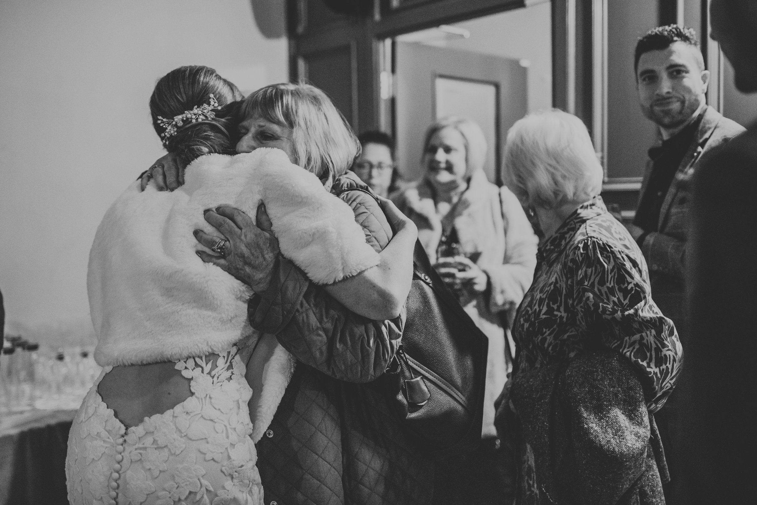 The bride hugs a wedding guest, photo in black and white. 