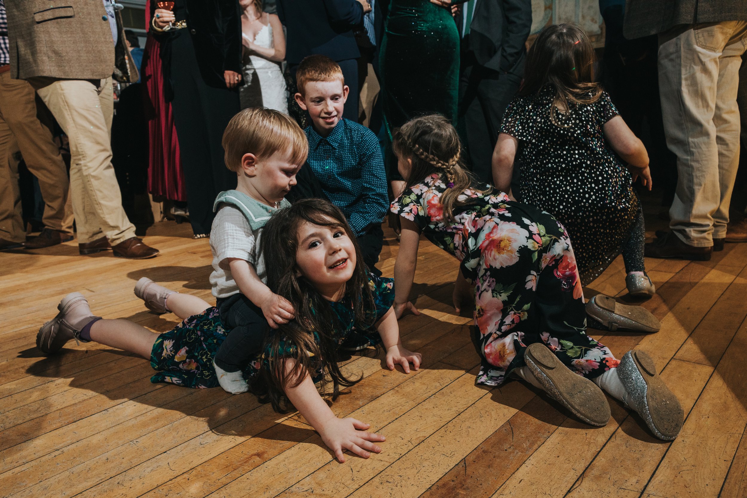 Children climbing on each others backs on the dance floor. 