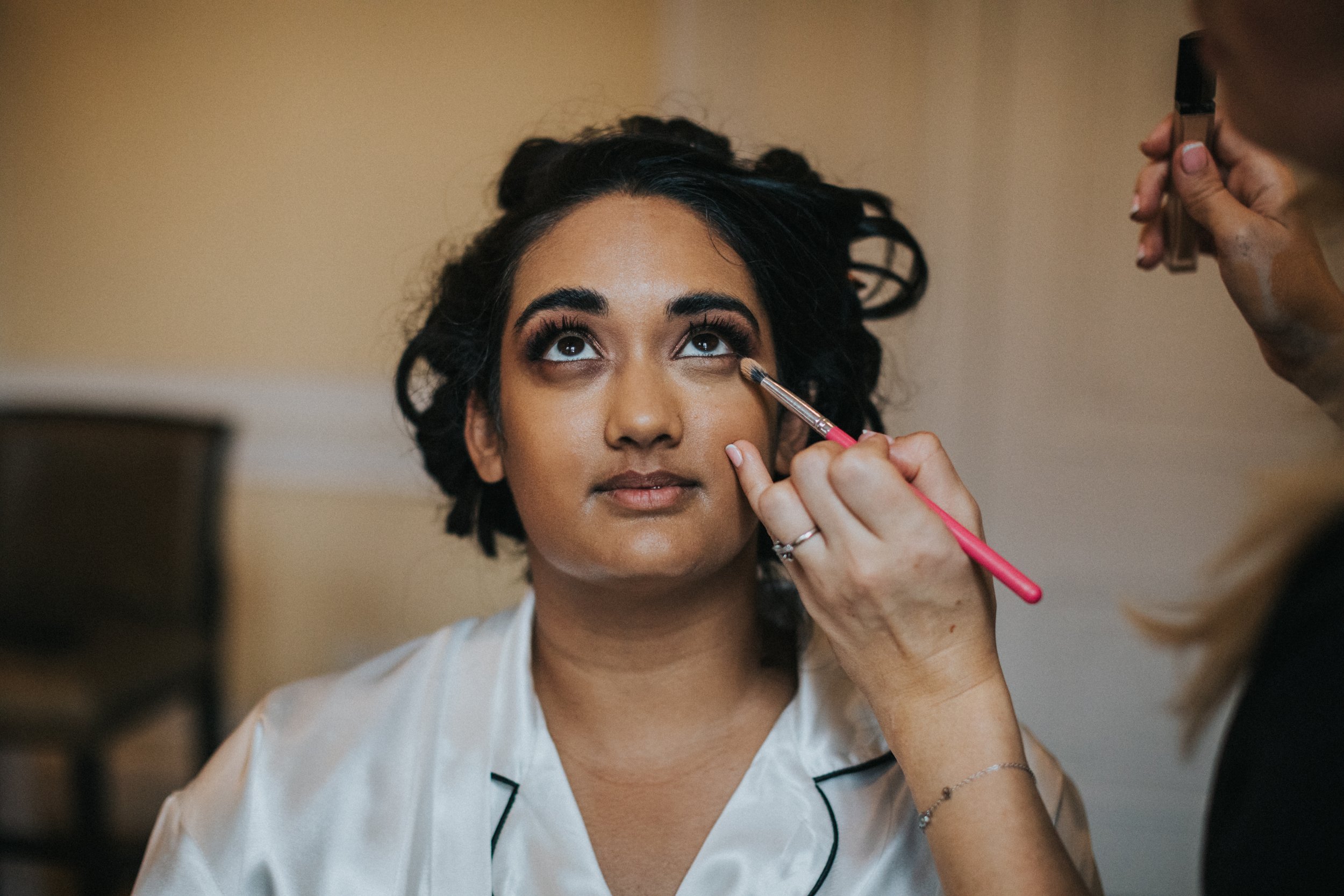 Close up of bride having her eye make up done. 