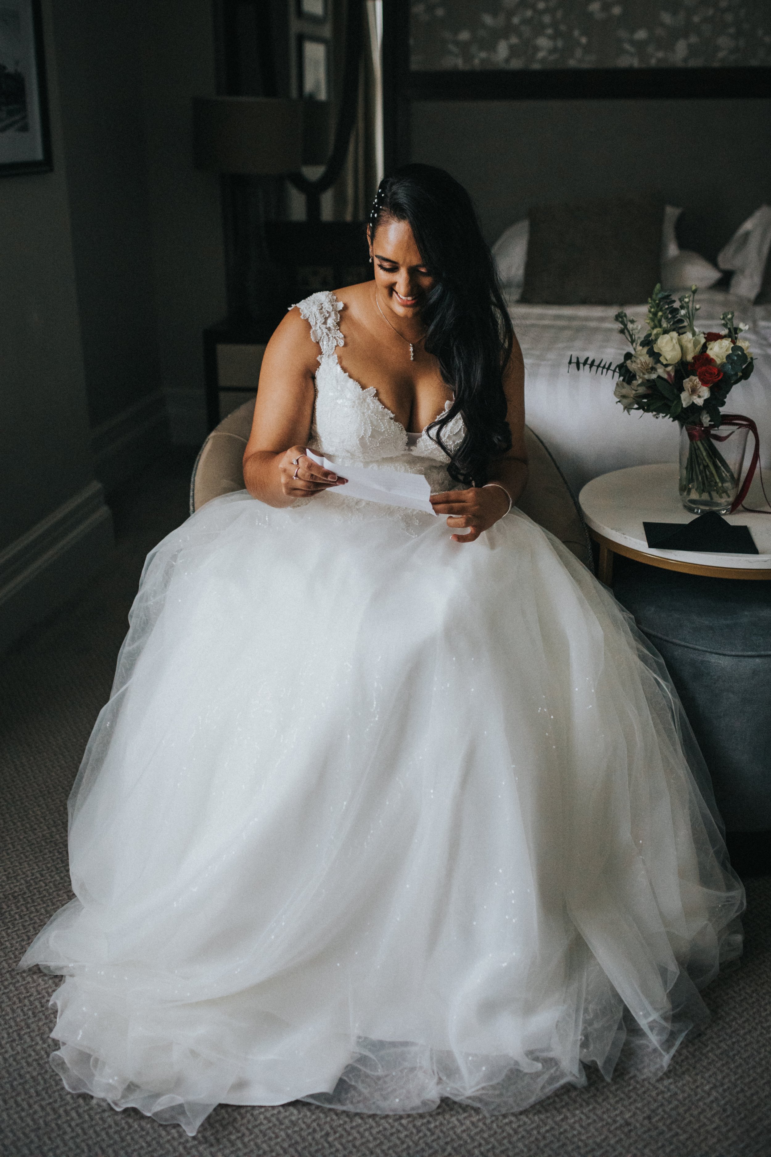 Bride laughing as she reads the letter. 