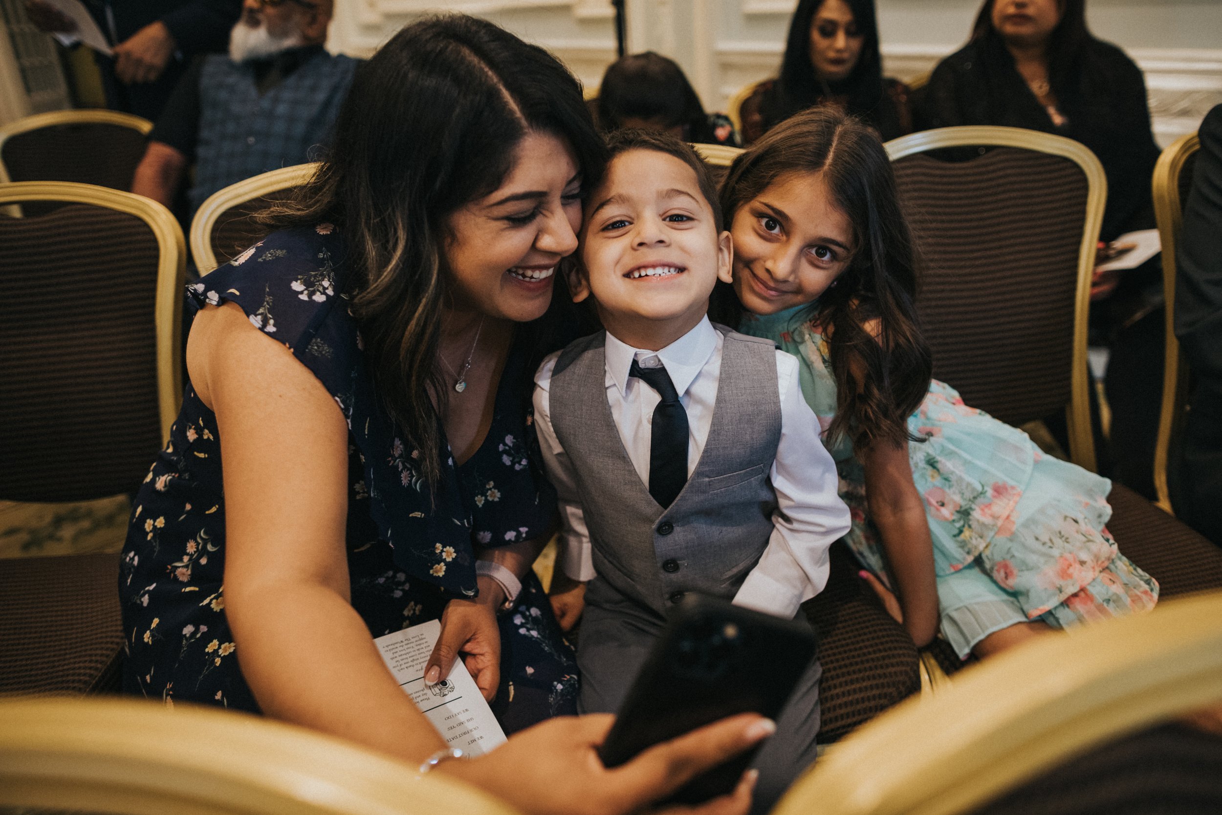 A mother and her two children take a selfie together. 