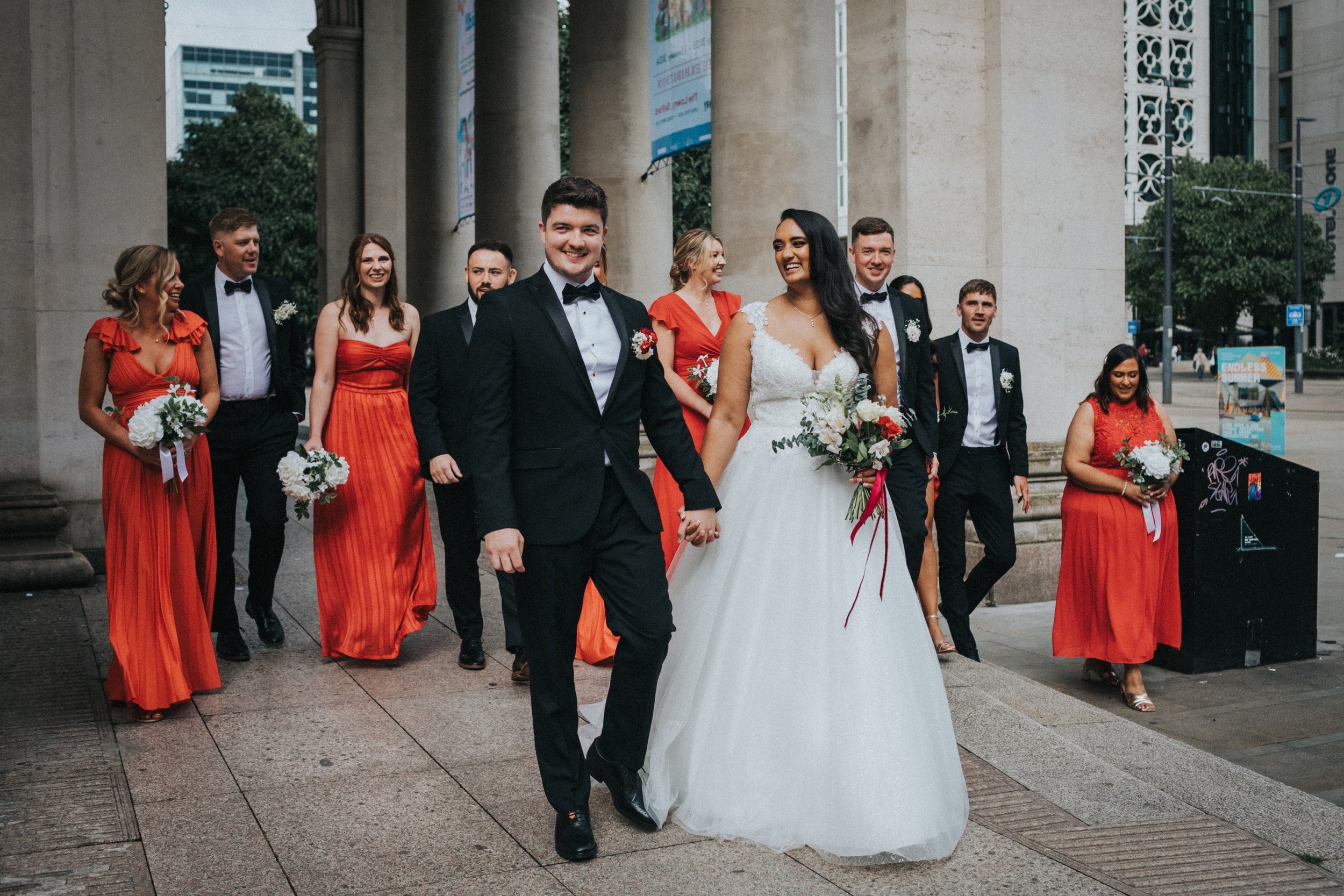 Bride and Groom walk together with their bridesmaids and groomsmen following them. 
