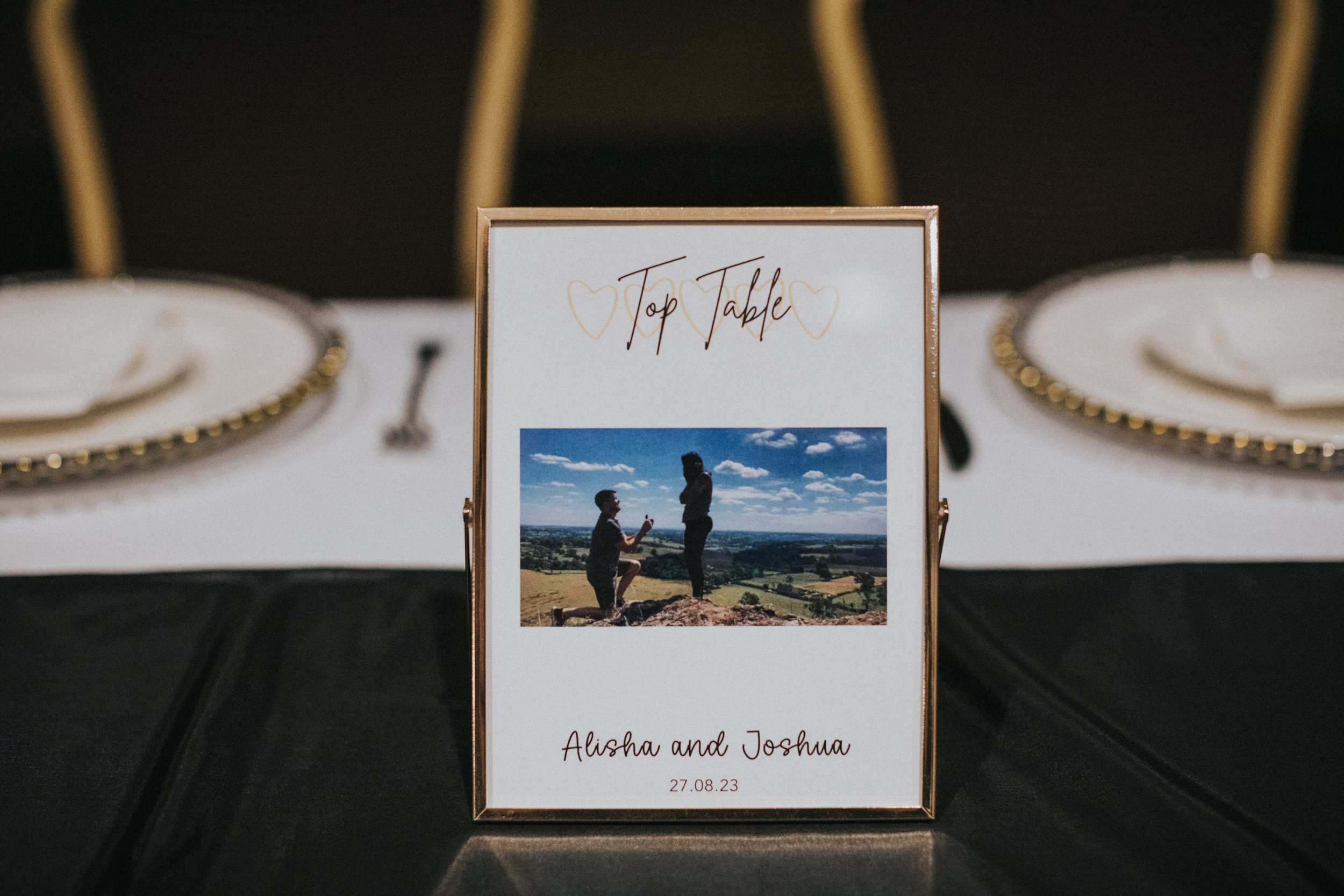 Top Table sign with a photo of the Groom proposing to the Bride. 