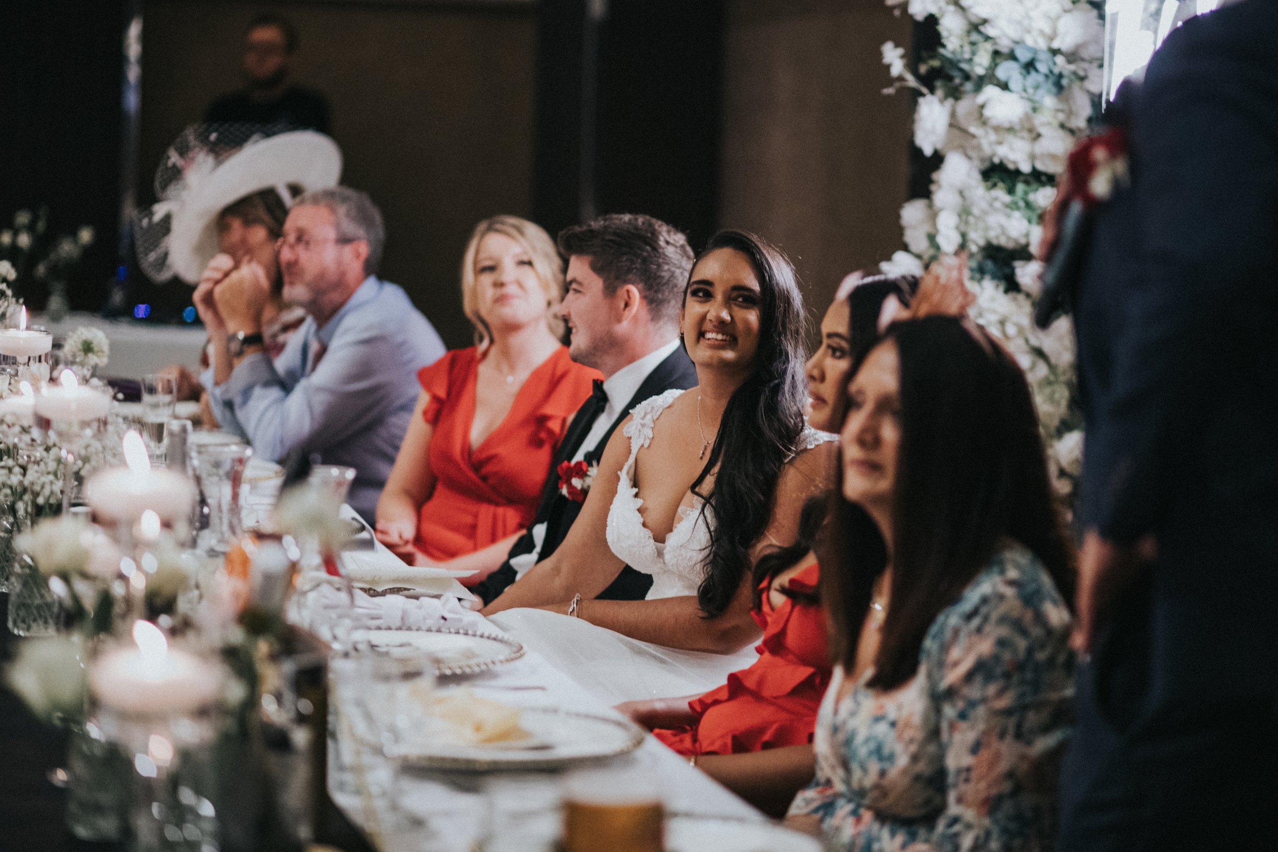 Bride smiles while listening to her fathers speech.