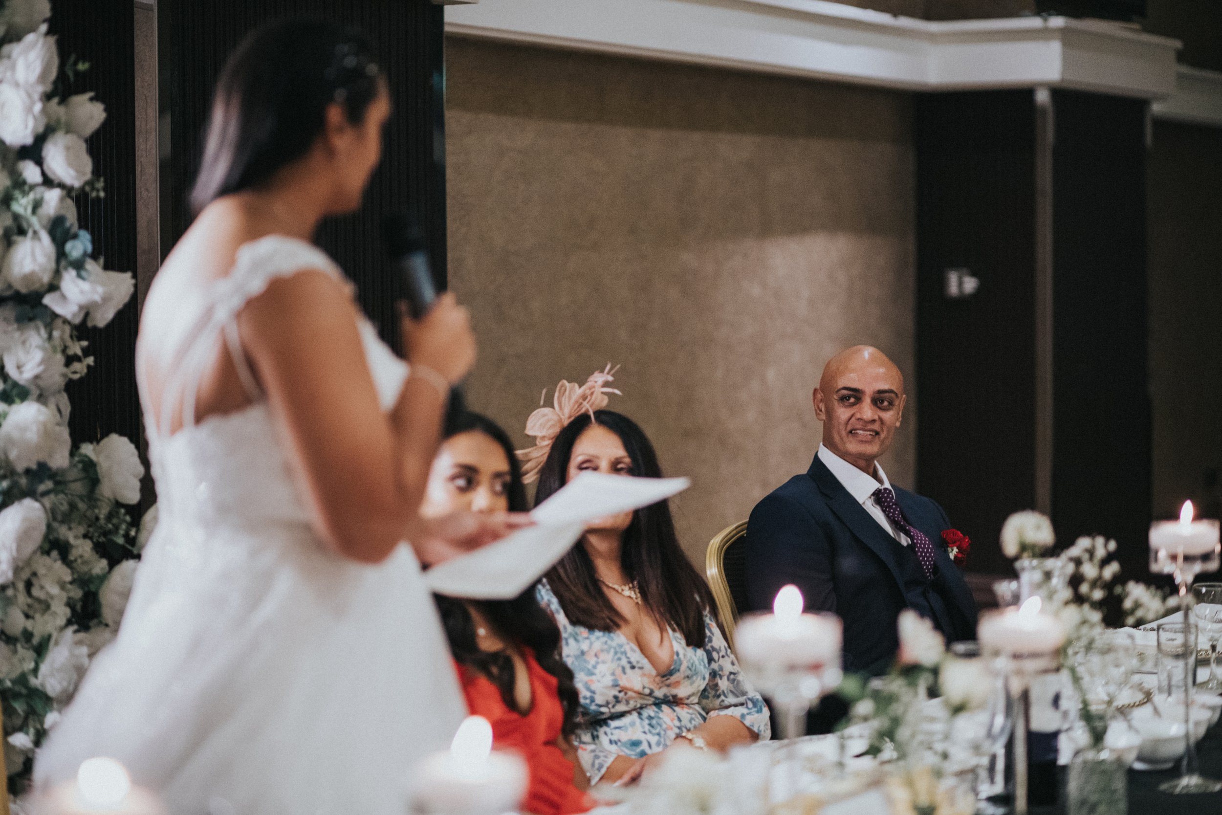 Brides father looks proud as he listens to her speech.