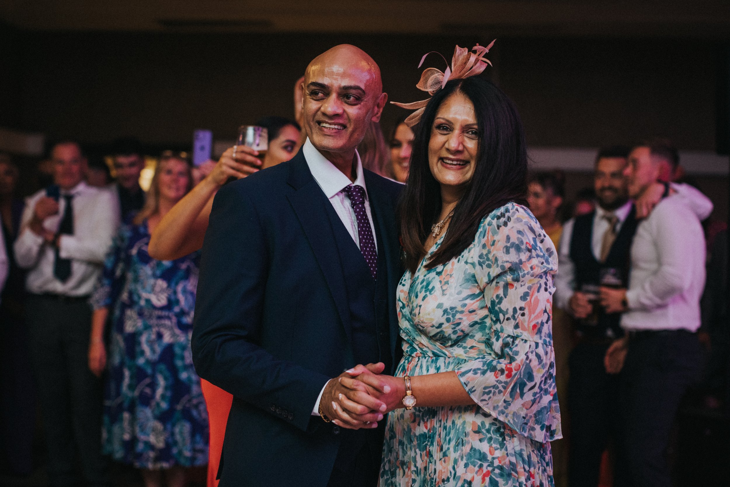 Mother and Father of the Bride dance together smiling.