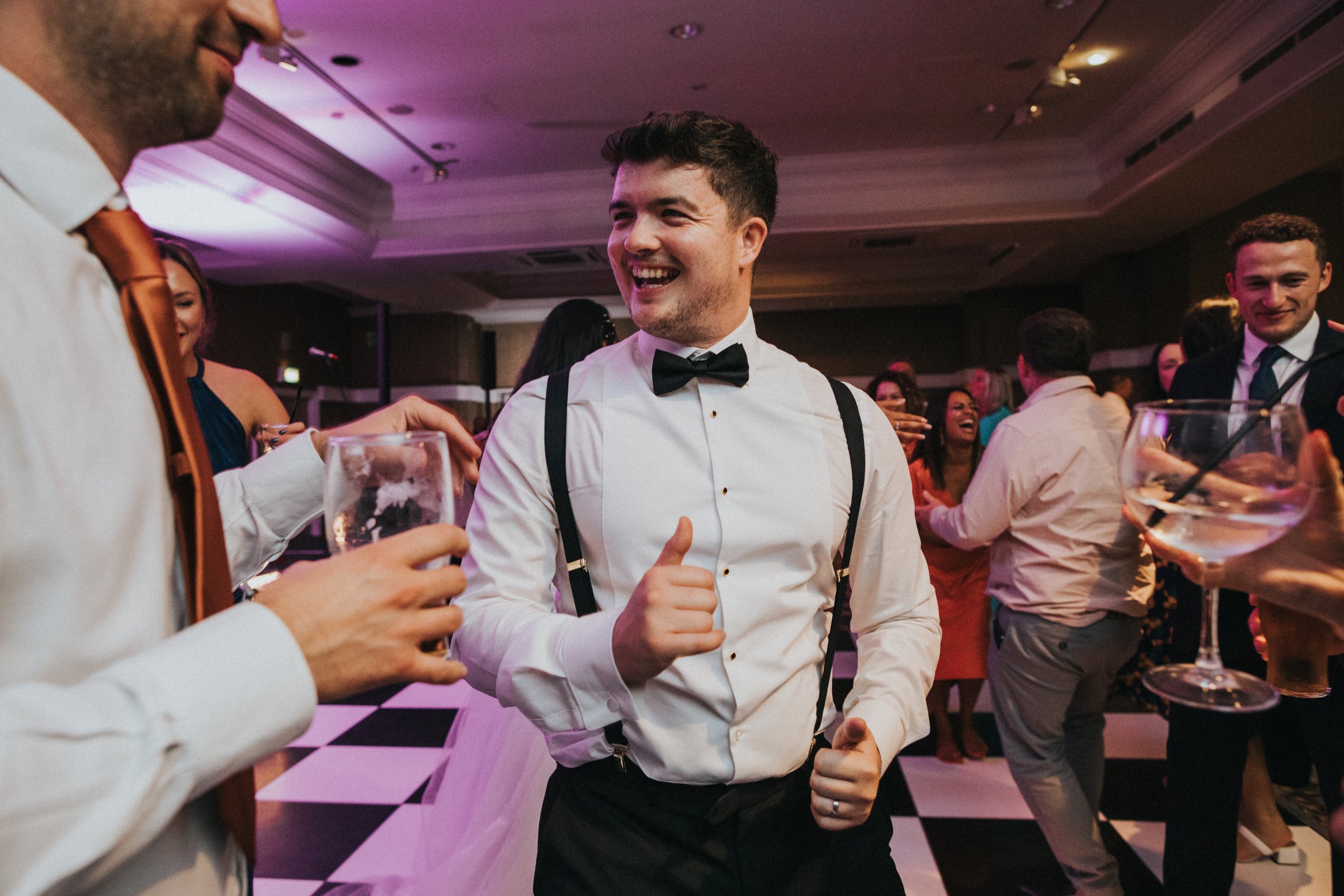 Groom laughing with his mates on the dance floor. 