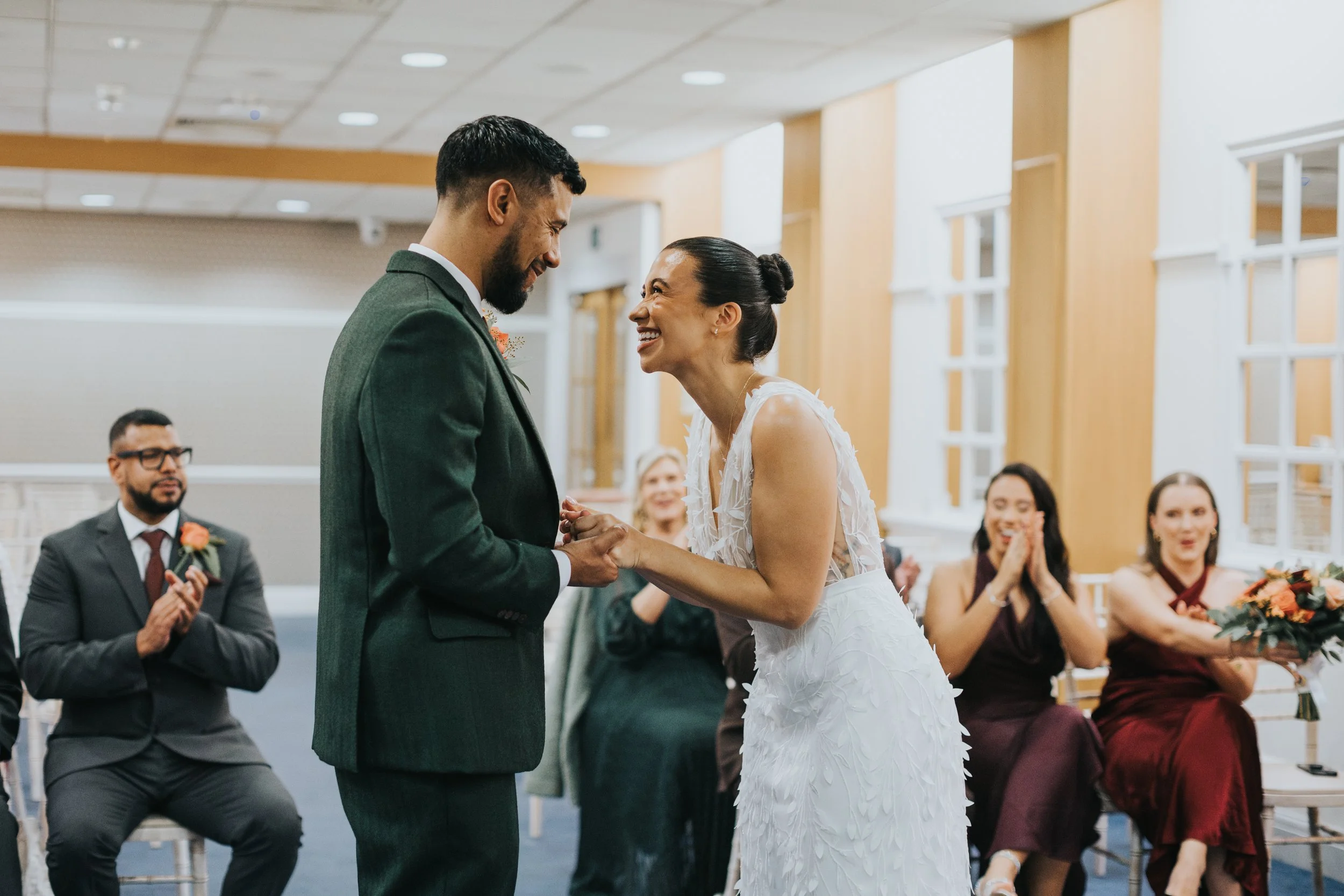 Bride and groom laughing looking at one and other