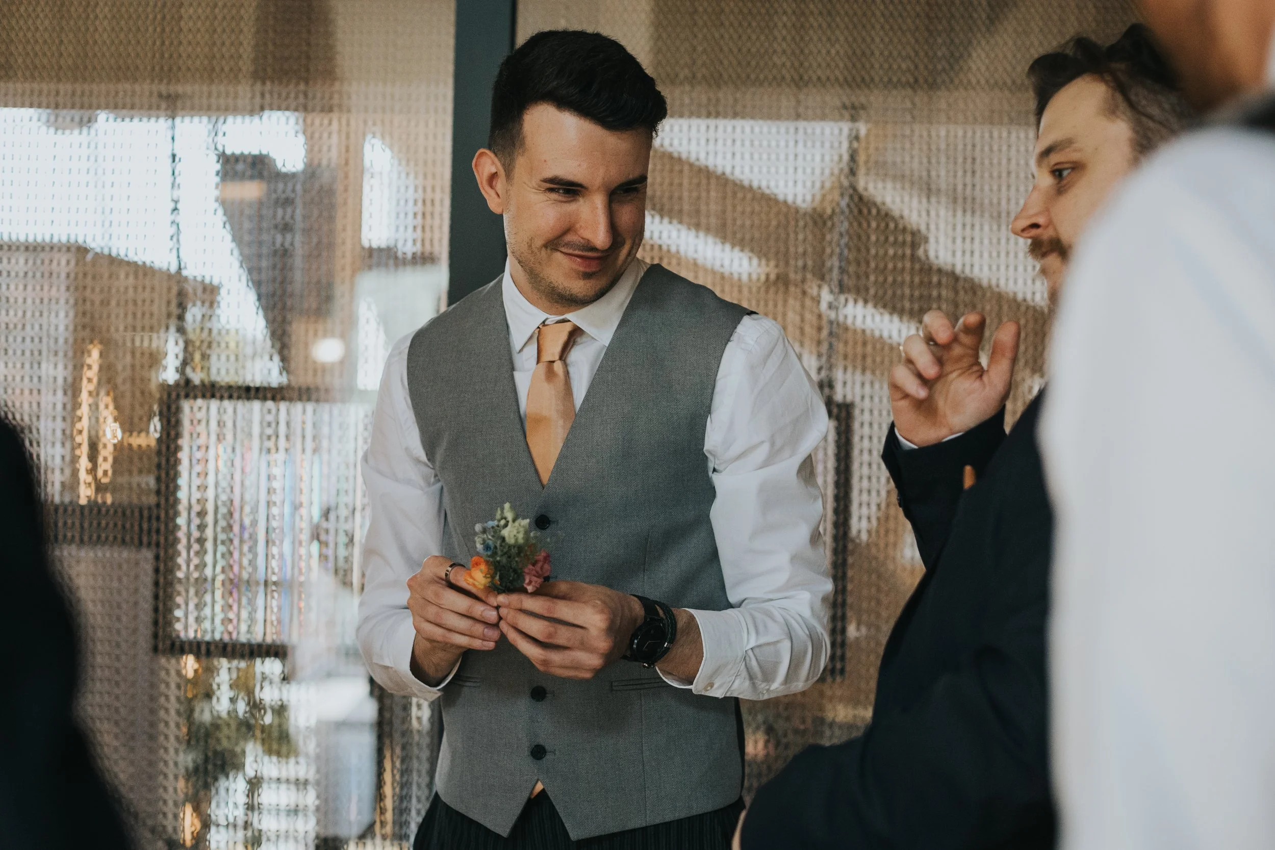 Groom holding his button hole flower.