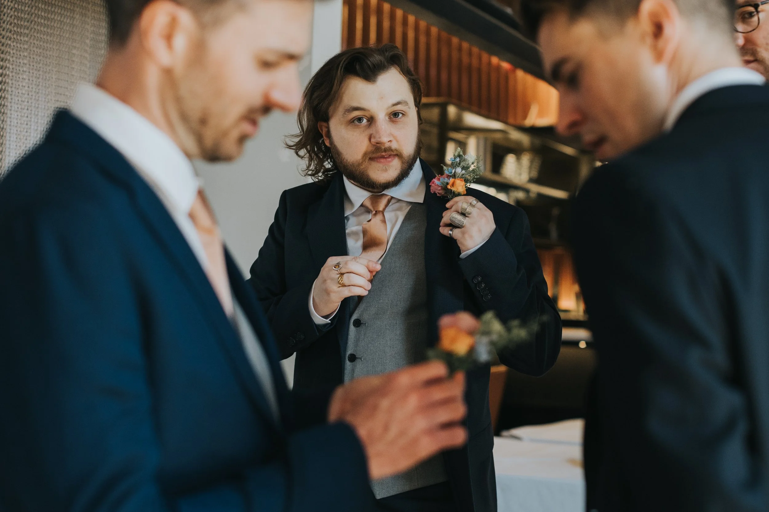 Best man putting on his button hole.