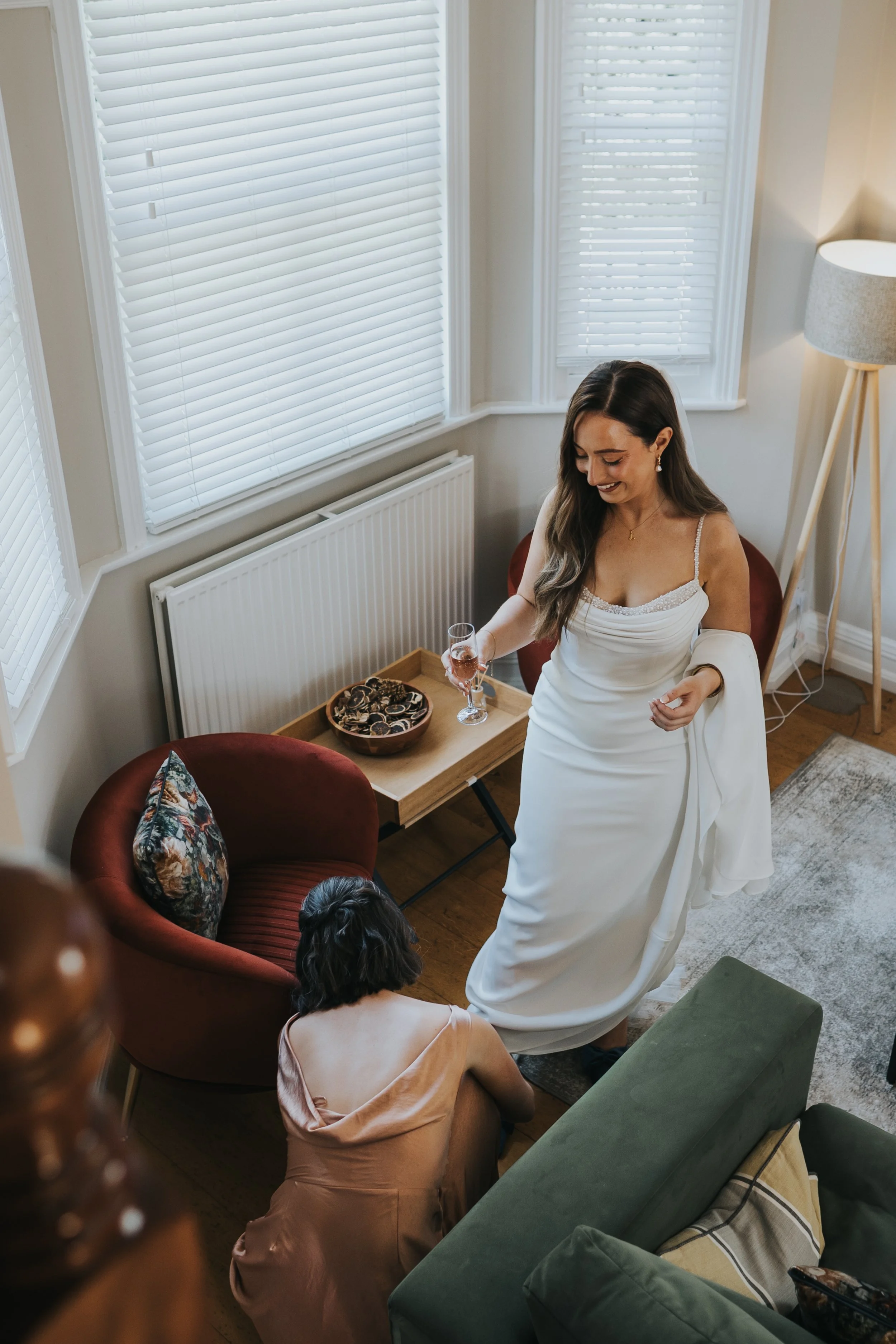 Bride having her show put on by her bridesmaid