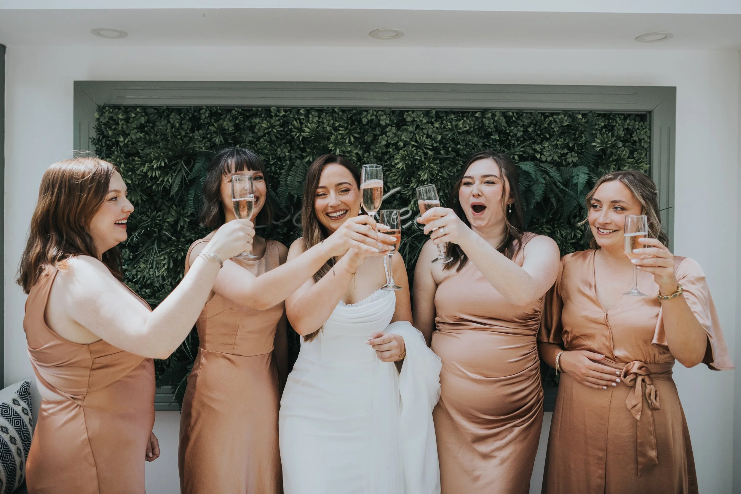 Bride and bridesmaids drinking champagne. 