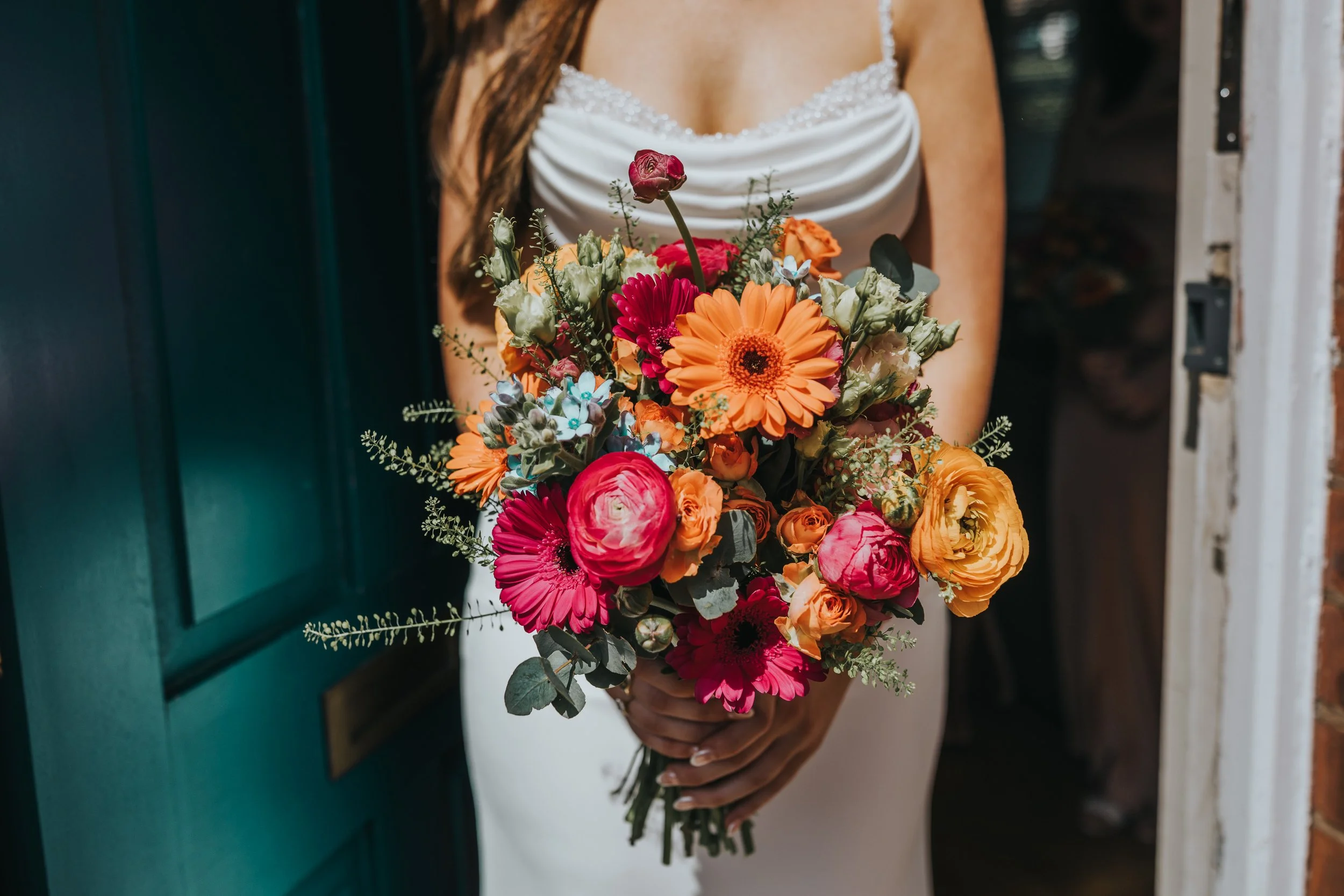 Close up of bridal bouquet, bright pink and orange flowers. 