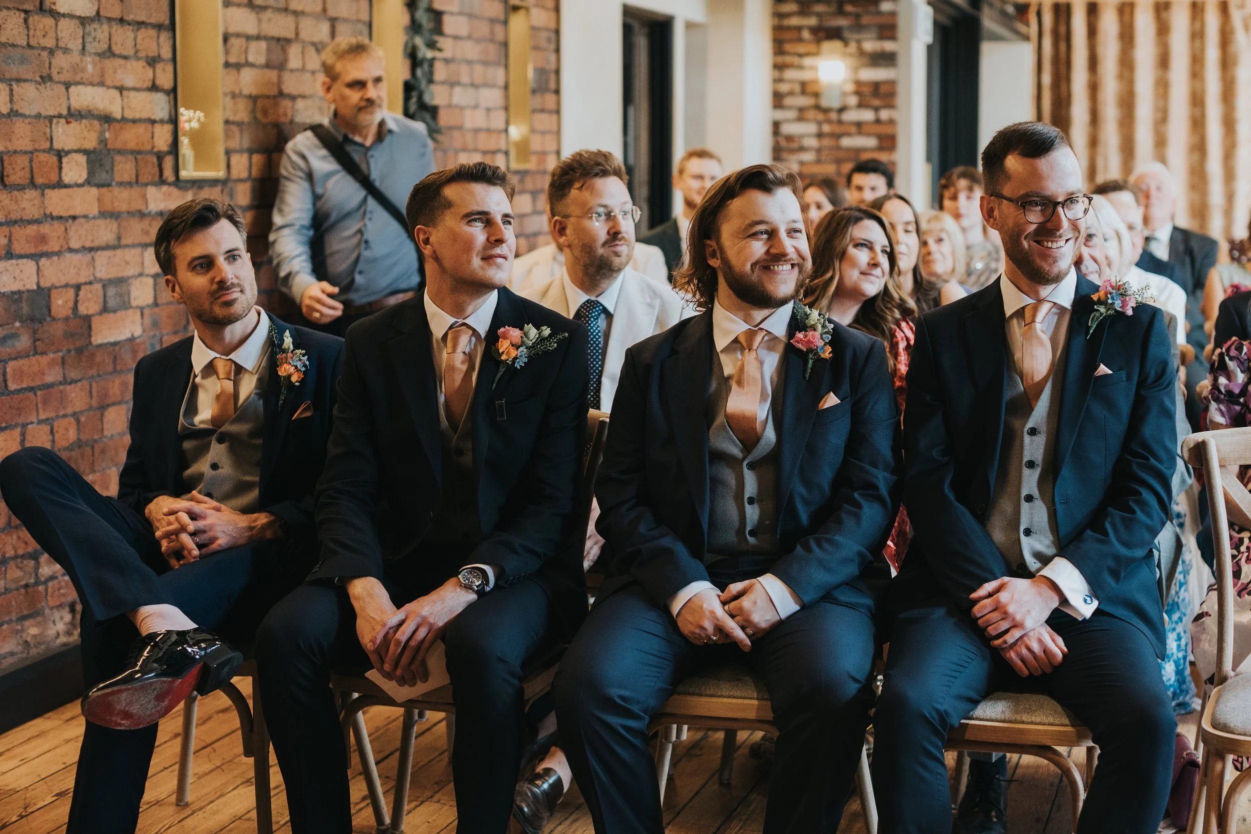 Groomsmen watch the ceremony in the Castlefield Rooms Manchester