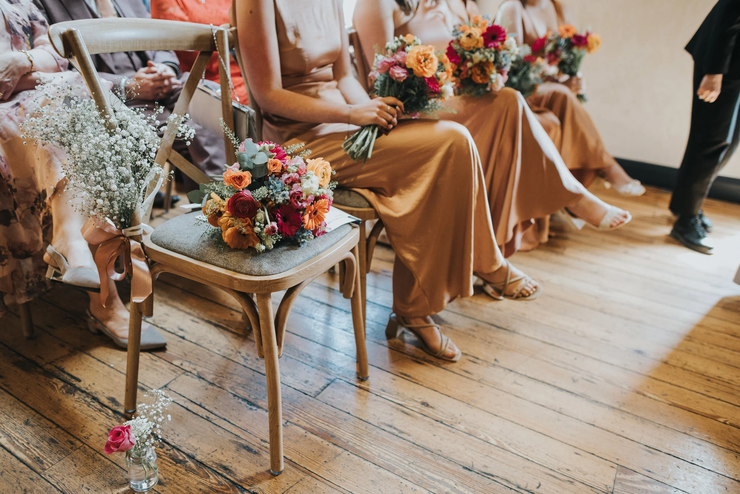 Close up of the brides flowers and the bridesmaids flowers on their laps. 