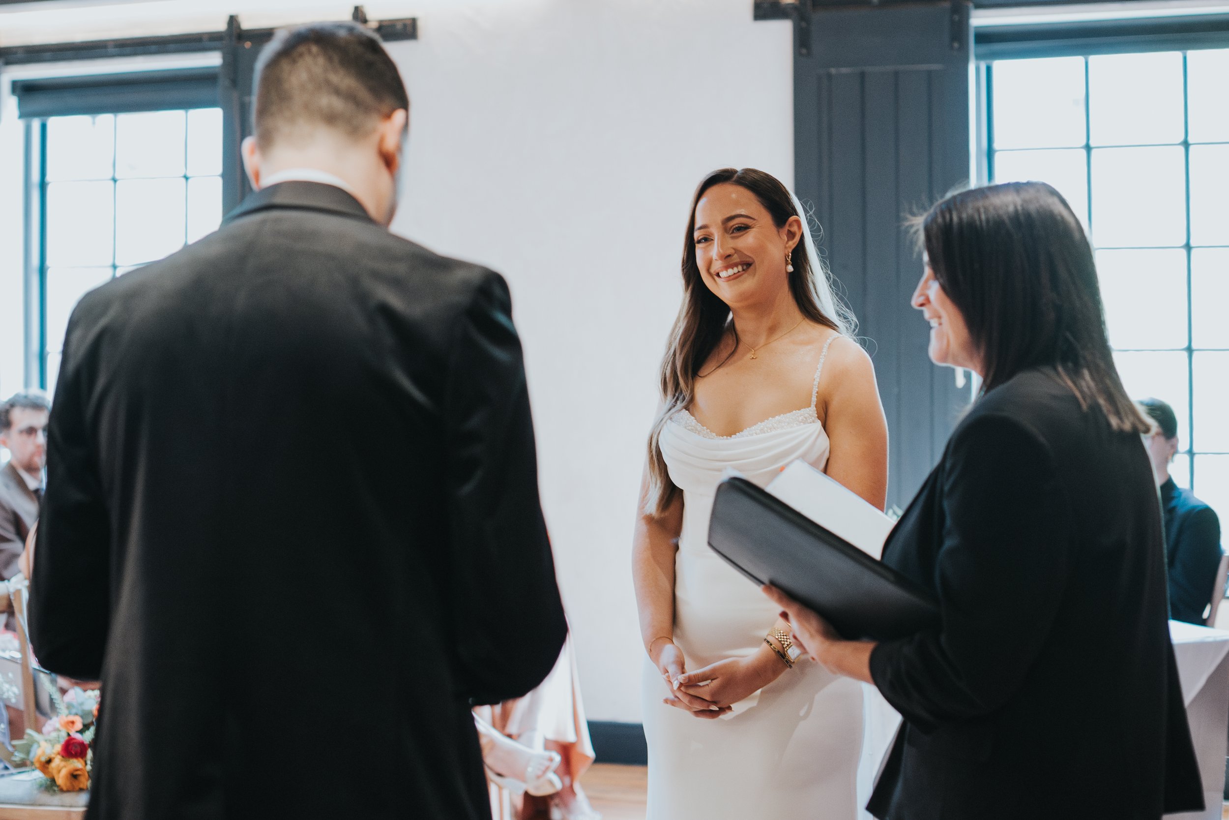 Bride smiles as she hears grooms speech.