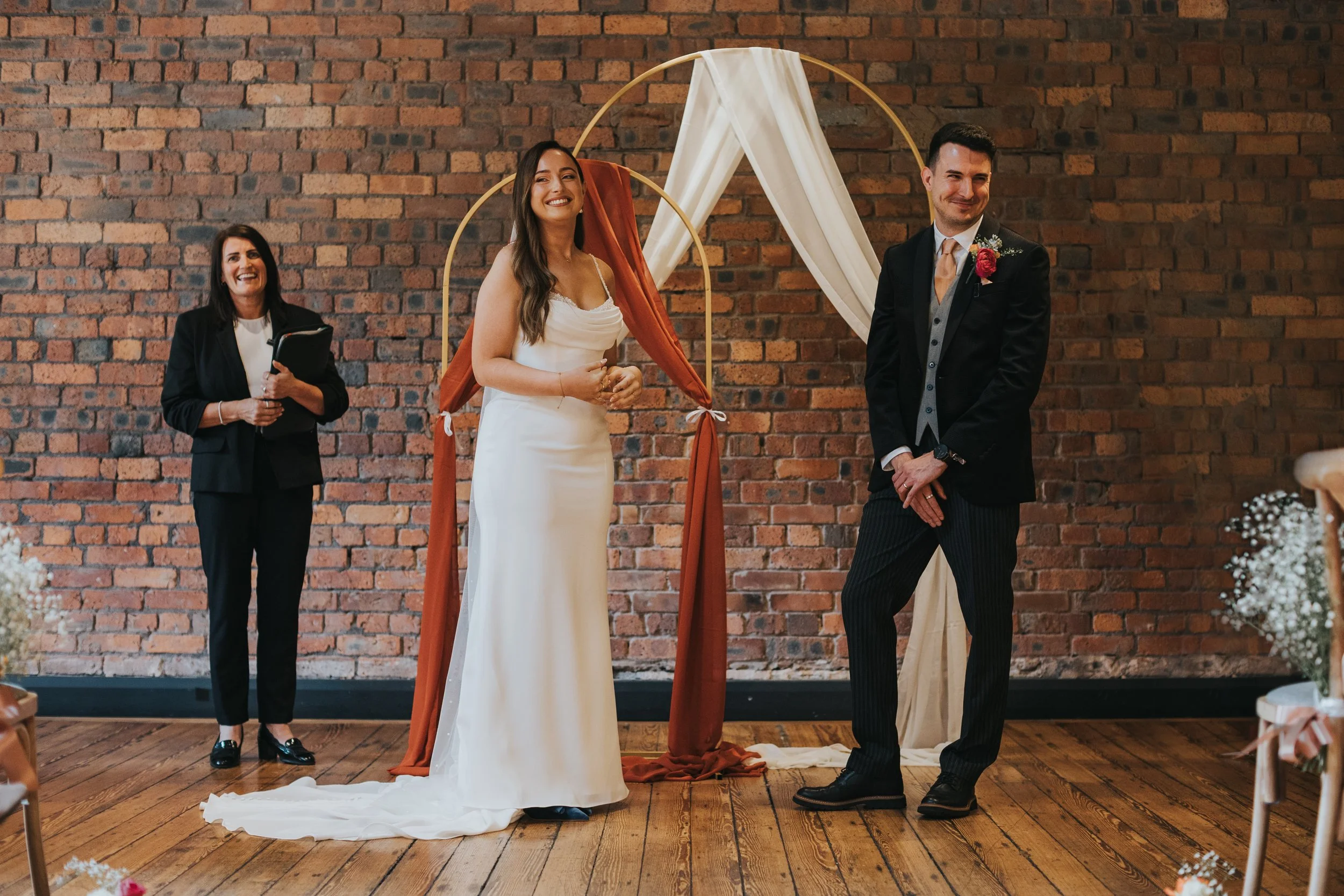 Bride and Groom look back towards guests laughing. 