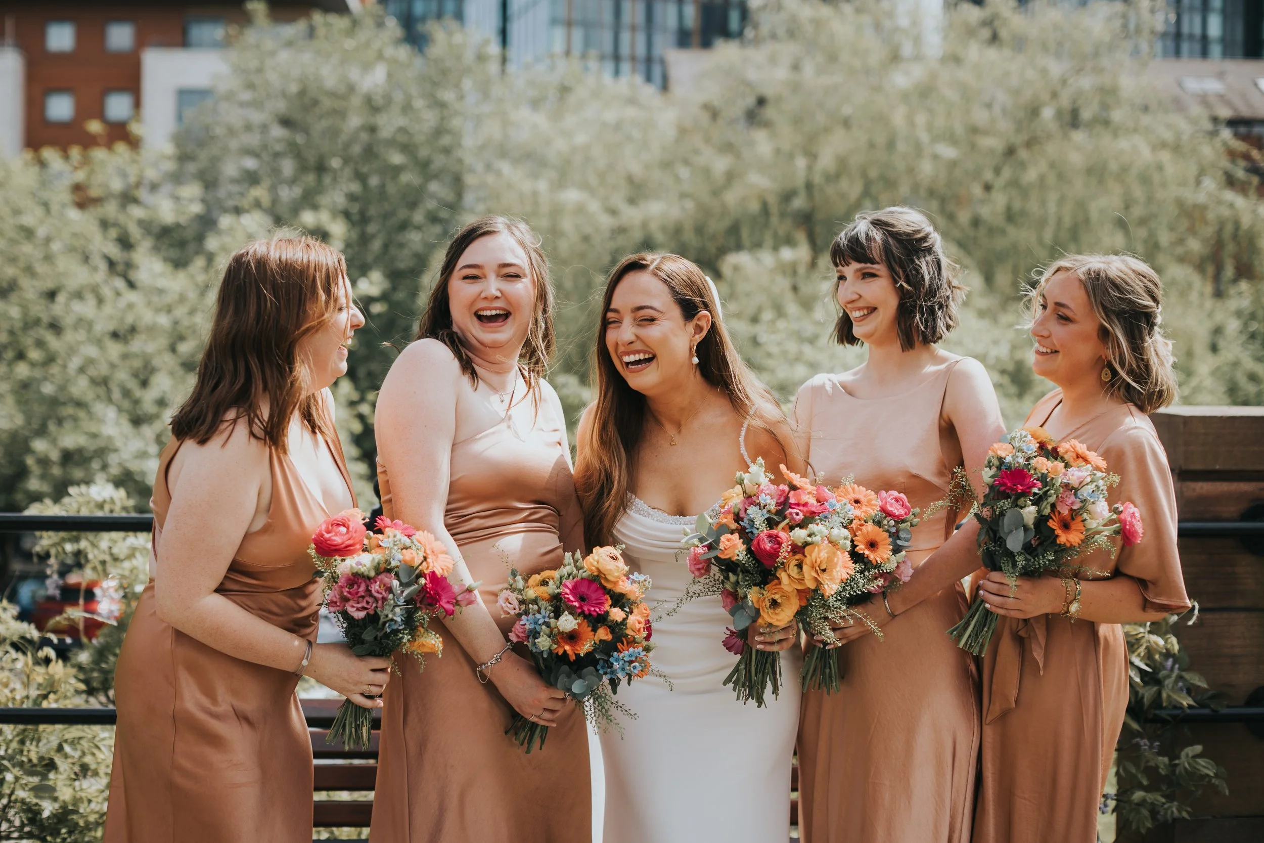 Bride laughing with bridesmaids in Manchester. 