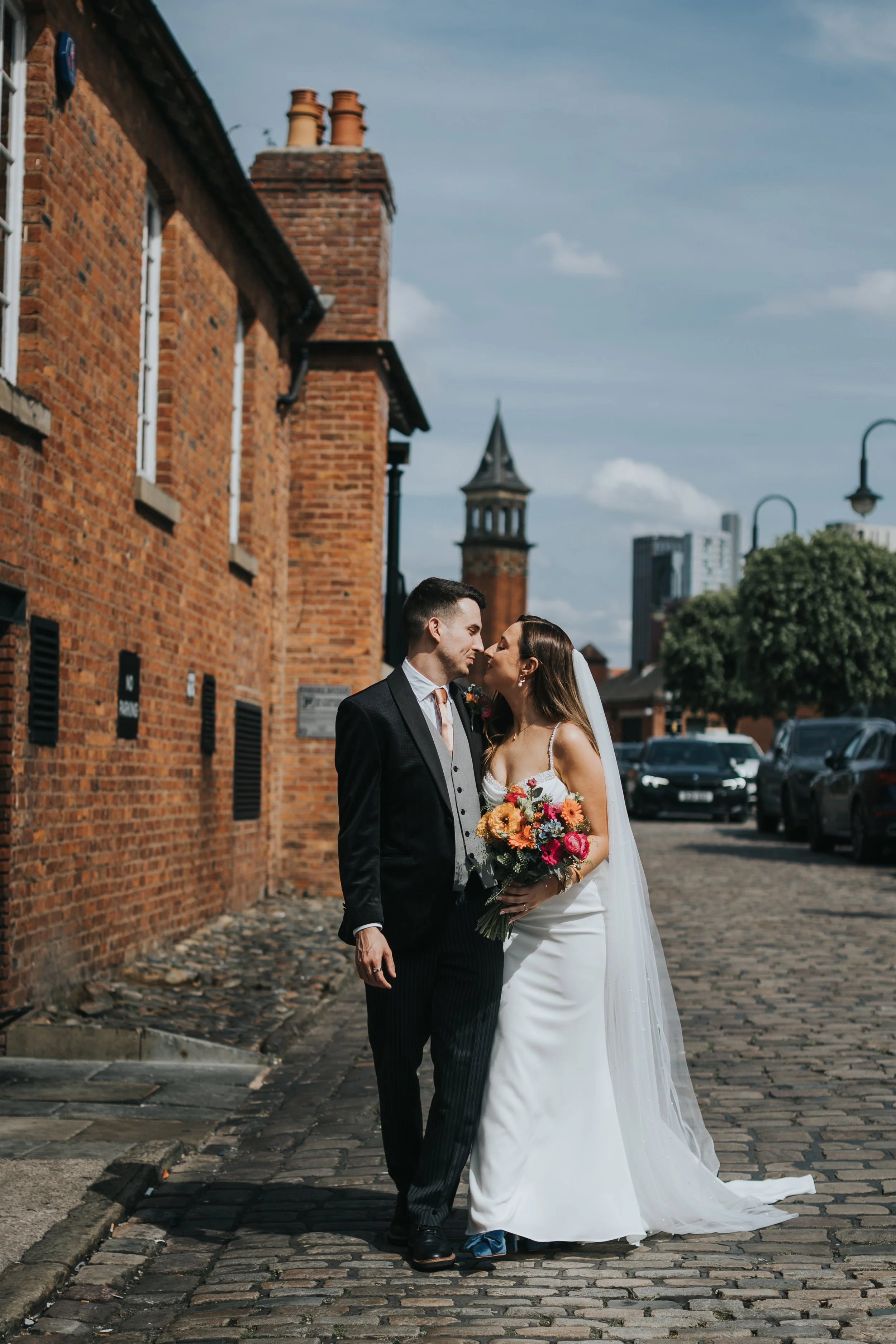 Bride and Groom kiss on cobbled street in Manchester