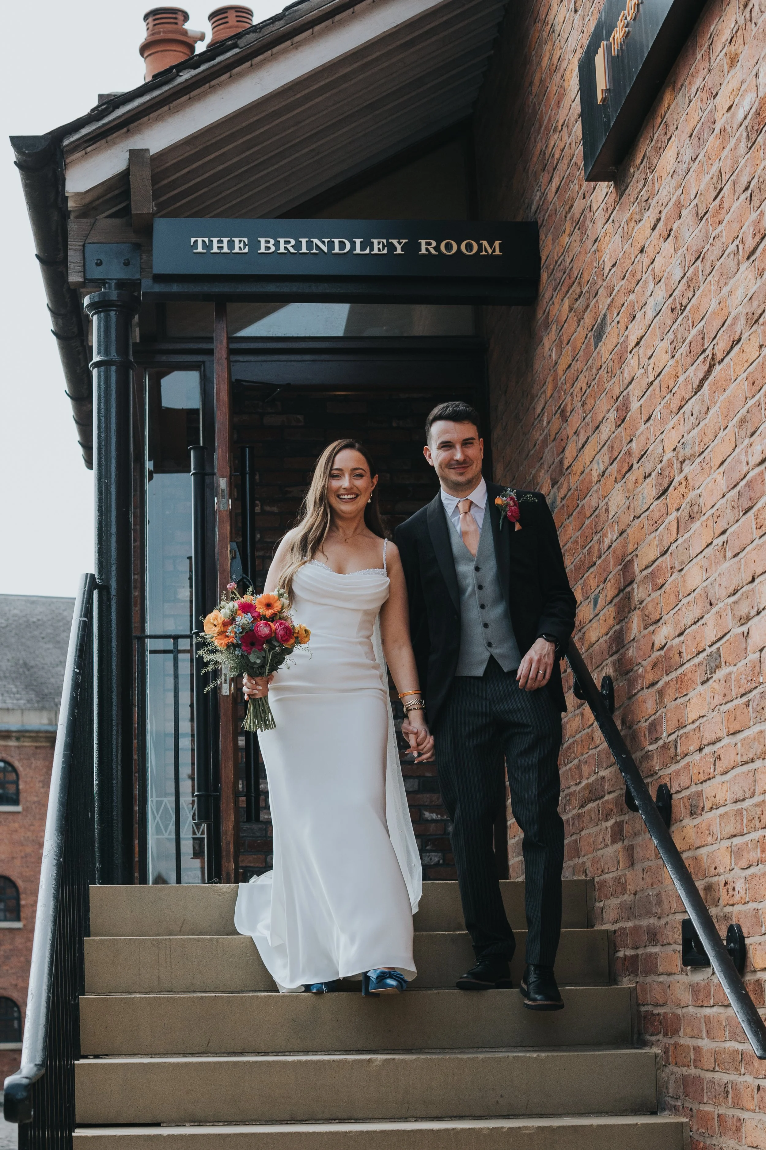 Bride and Groom coming down the steps of The Castlefield Rooms Manchester. 